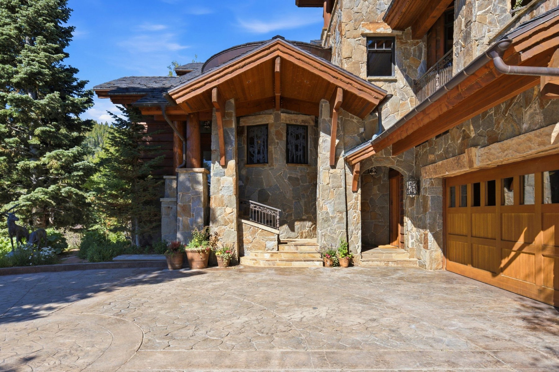 Stone facade residence with a prominent gabled entry featuring exposed wood beams and columns