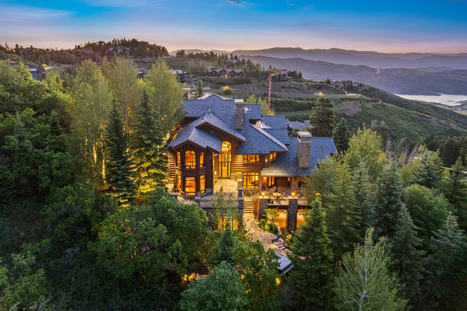 Multi-level property featuring extensive stonework, wood siding, and multiple balconies