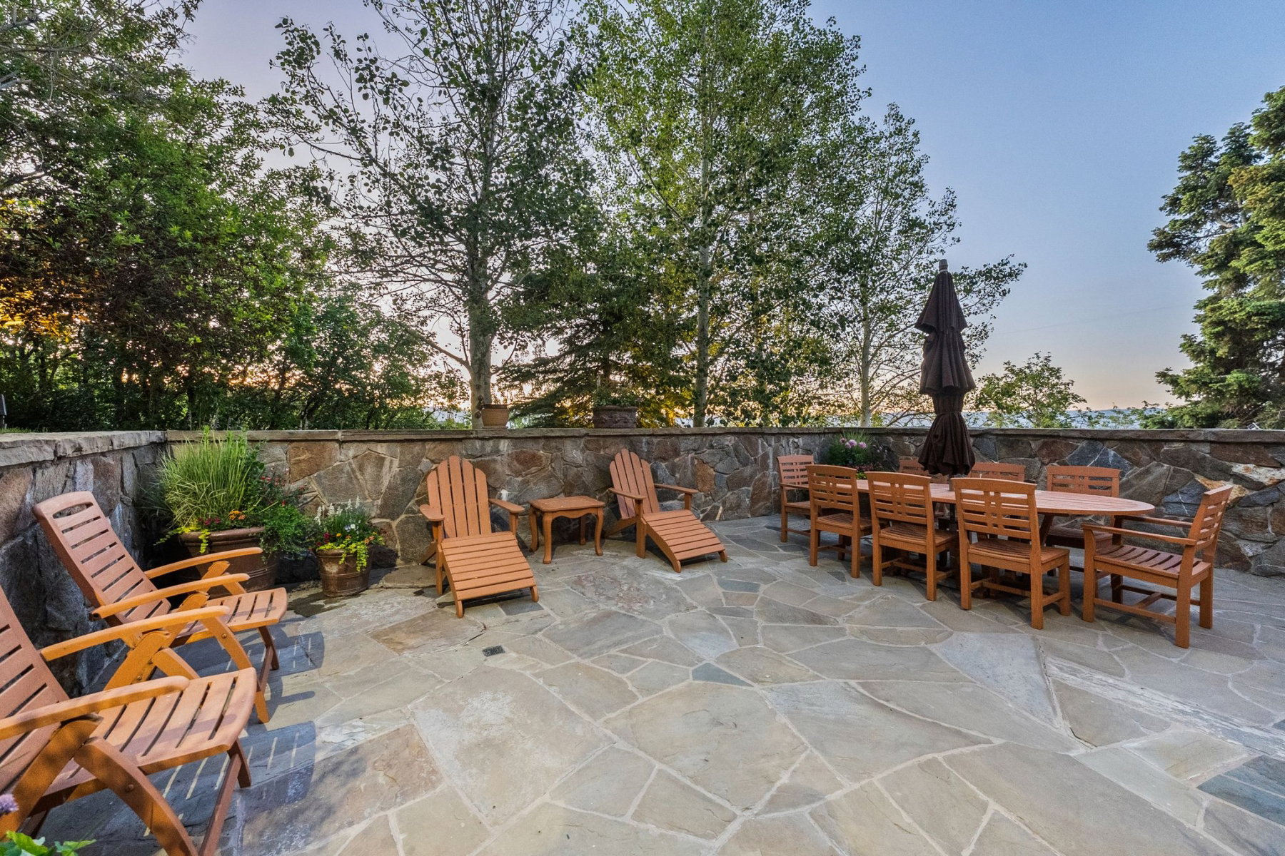 Expansive flagstone patio with a natural stone retaining wall