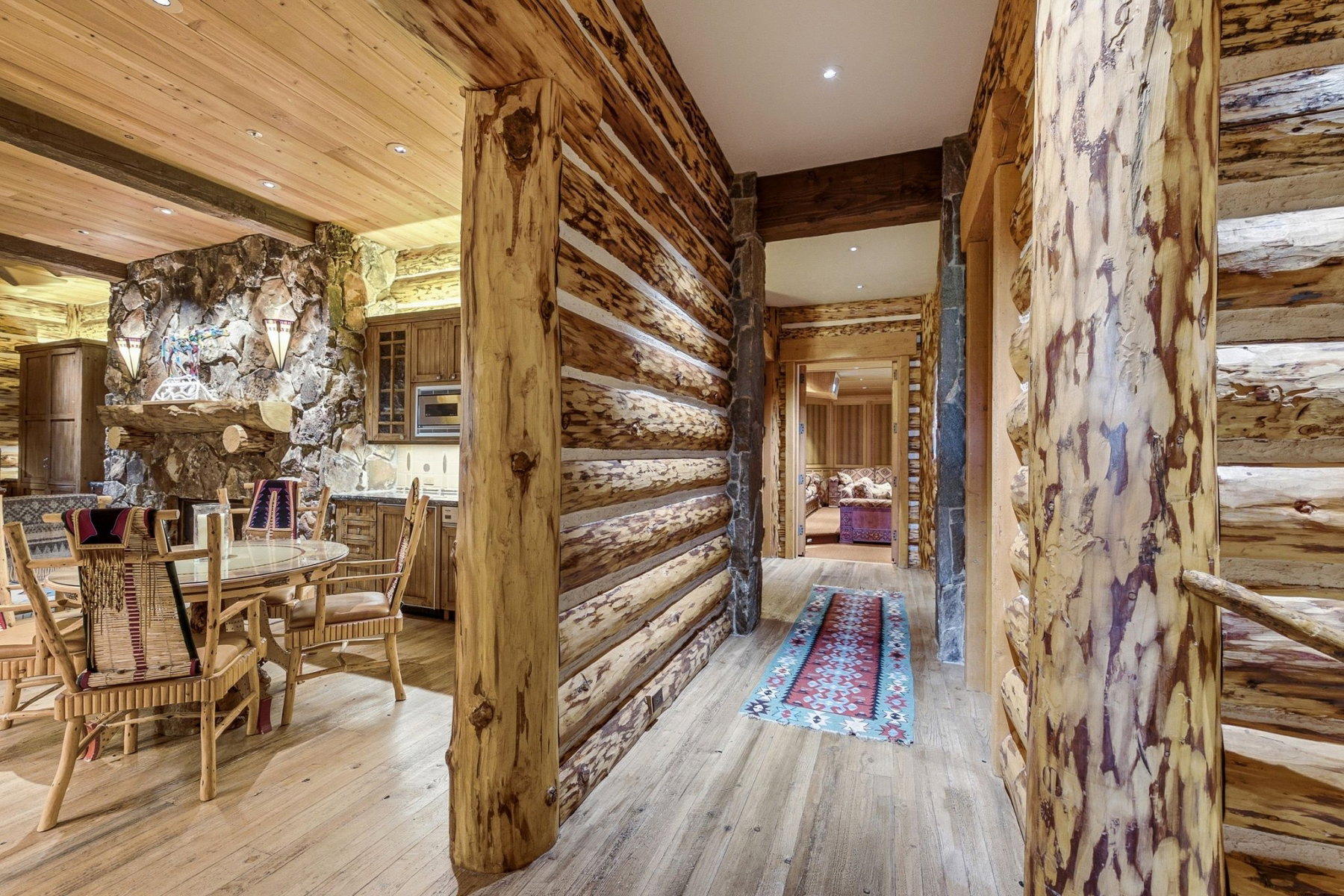 Log-hewn interior walls with exposed natural wood beams and light wood-finish flooring