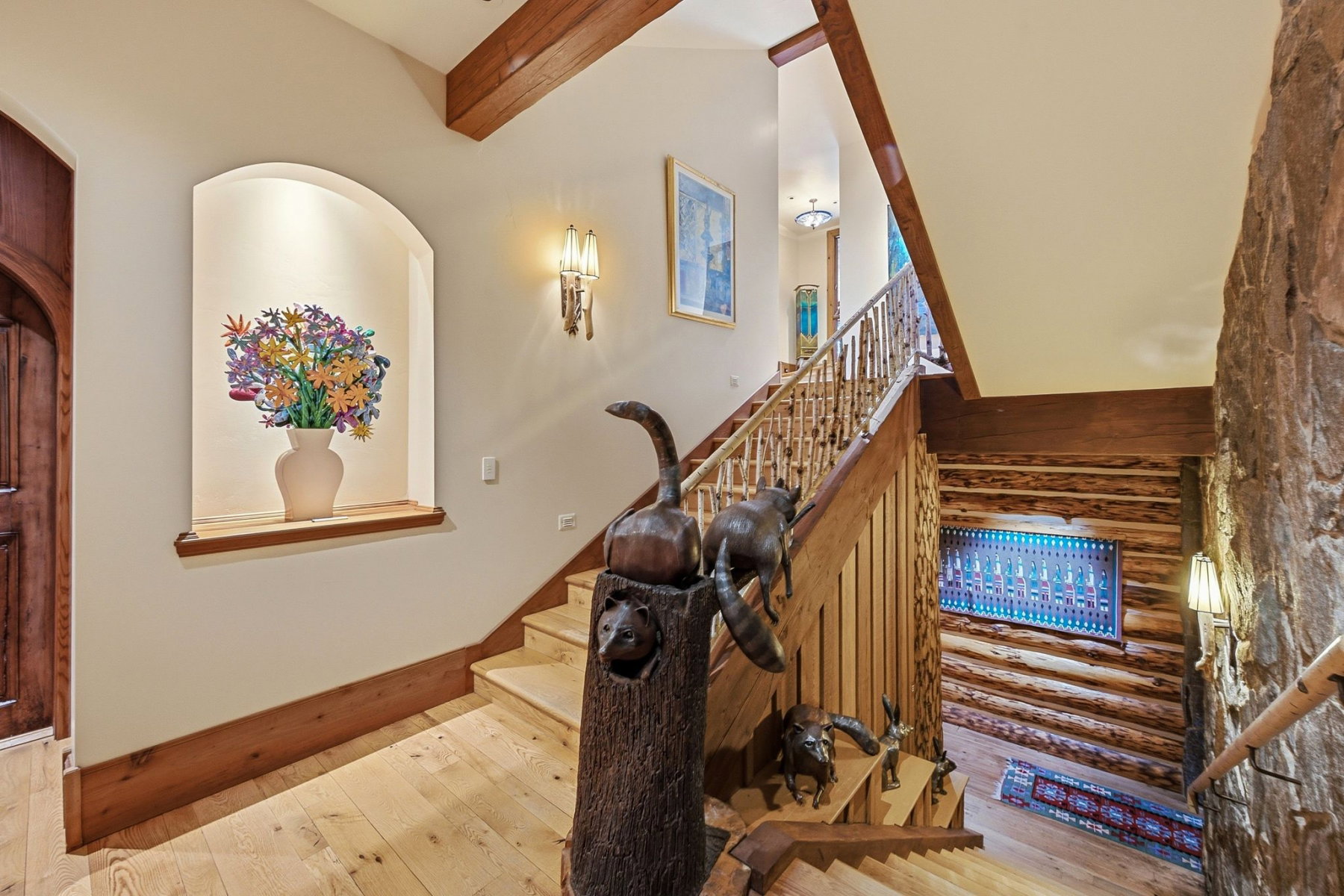 Staircase featuring wood-finish treads and risers, natural wood railings, and exposed wood ceiling beams