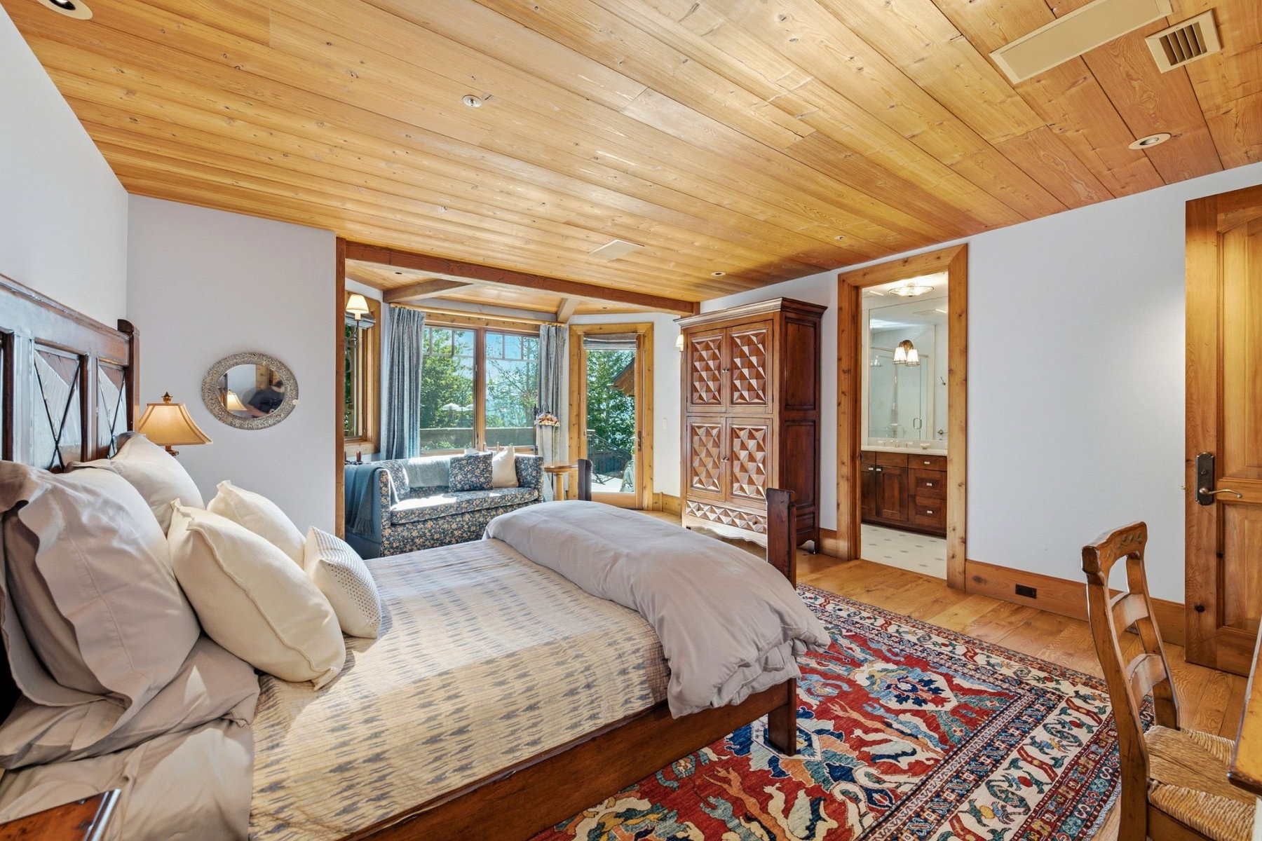 Spacious room with wood-finish flooring, a wood-paneled ceiling, and a distinct windowed alcove