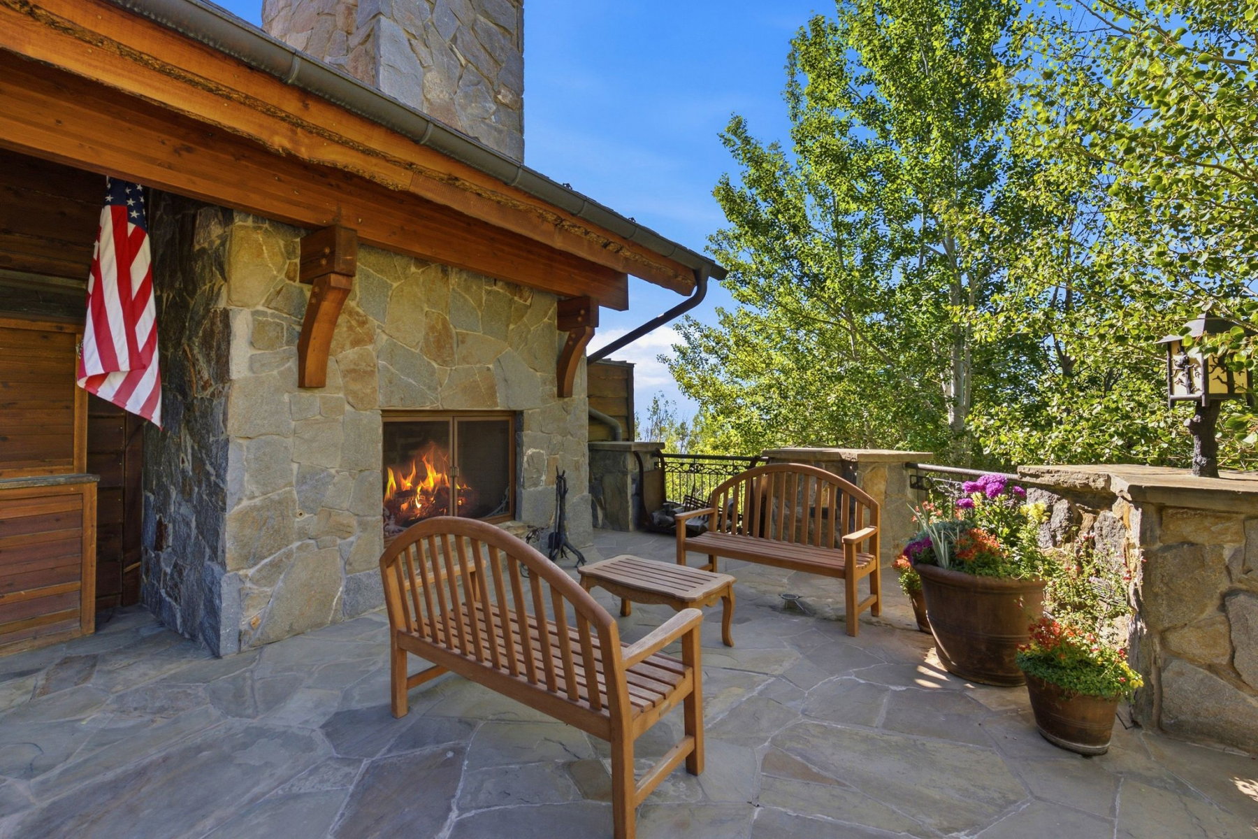 Outdoor patio featuring a stone-clad fireplace and flagstone flooring
