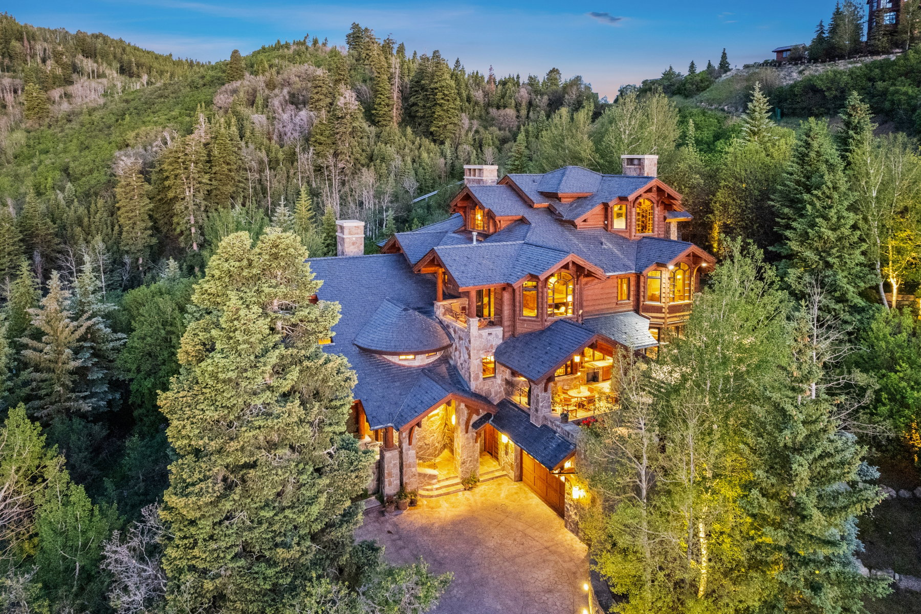 Multi-level mountain residence featuring stone and wood siding, prominent gables, and multiple balconies
