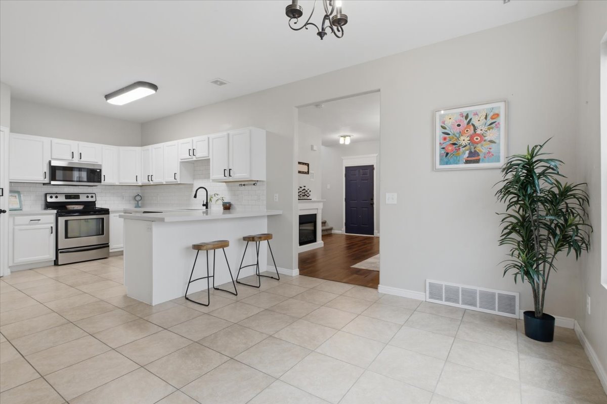 Kitchen with white cabinetry, stainless steel appliances, and a subway tile backsplash