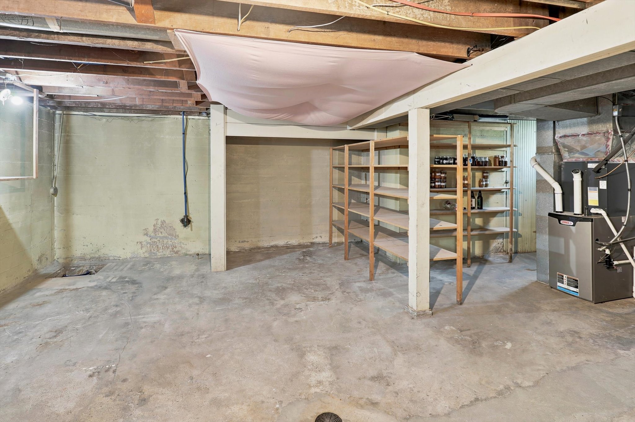 Unfinished basement featuring concrete flooring and exposed ceiling joists
