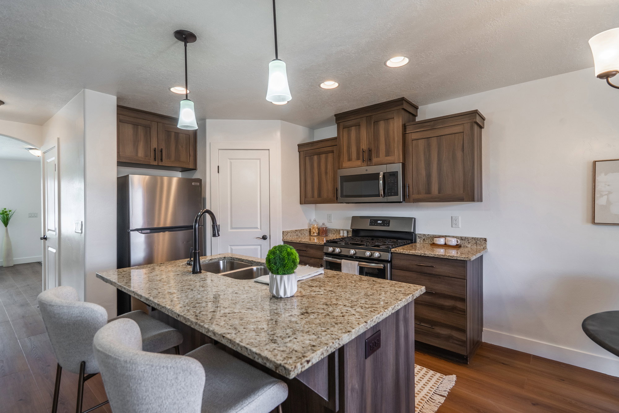 Kitchen featuring a central island with a double basin sink and granite countertop
