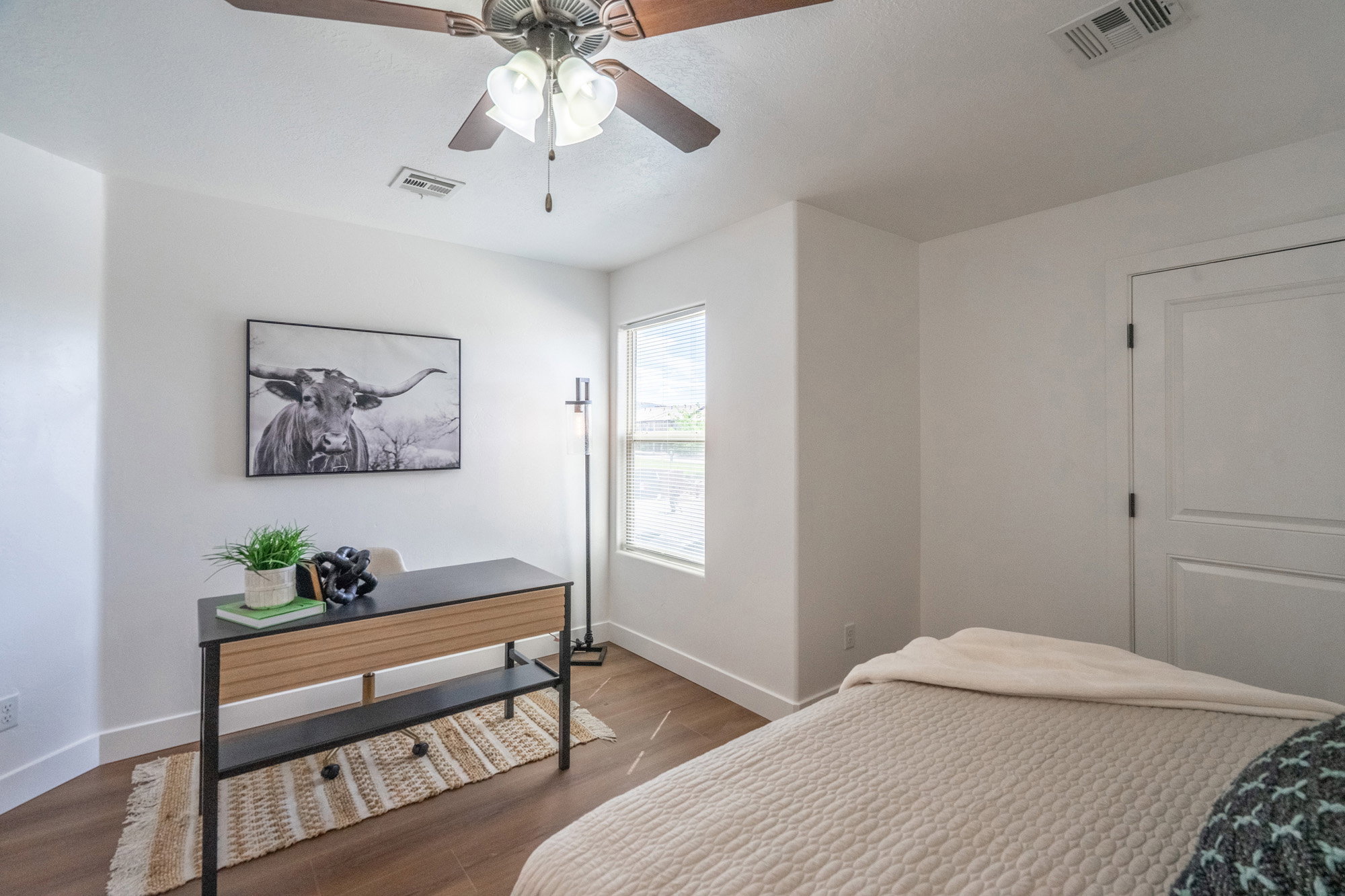 Interior room featuring wood-finish flooring and a ceiling fan with integrated lighting