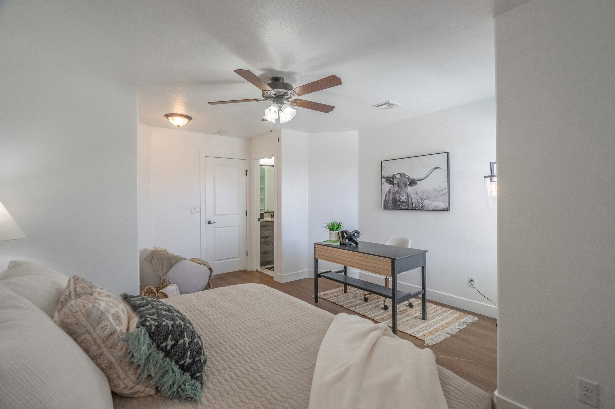 Spacious bedroom featuring wood-finish flooring, a contemporary ceiling fan, and recessed lighting