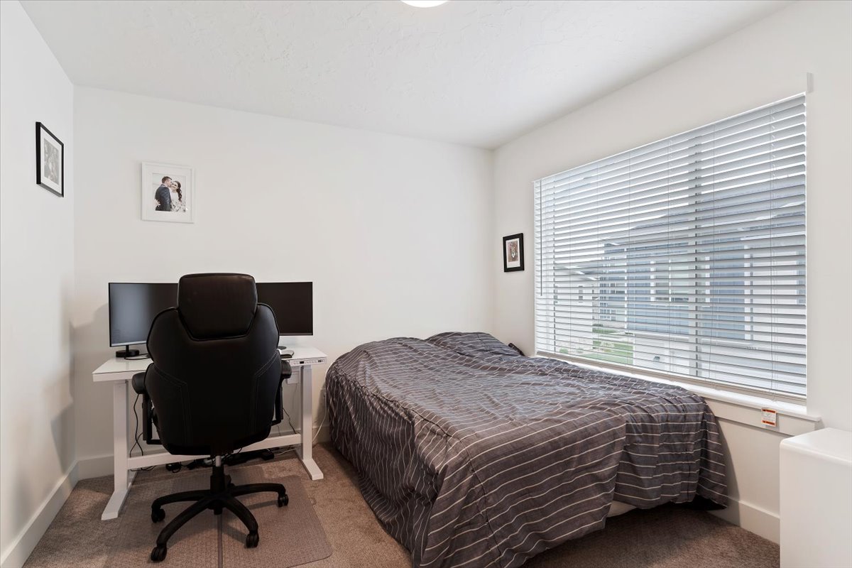 Carpeted room featuring a large window with blinds, white walls, and a recessed ceiling light
