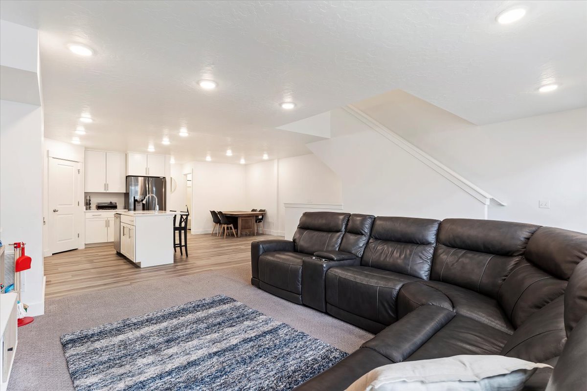 Open-concept living area featuring recessed lighting, light wood-finish flooring, and a kitchen island with seating
