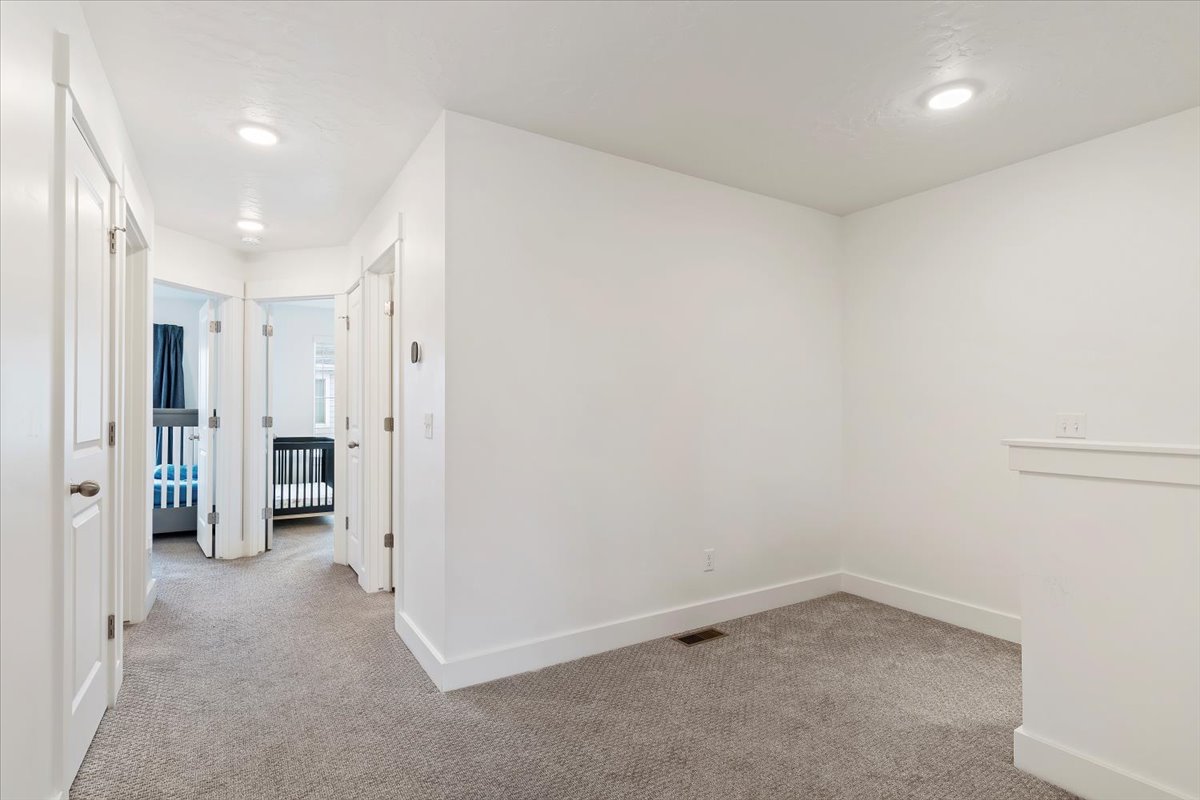 Carpeted interior space featuring white walls, white trim, and recessed lighting