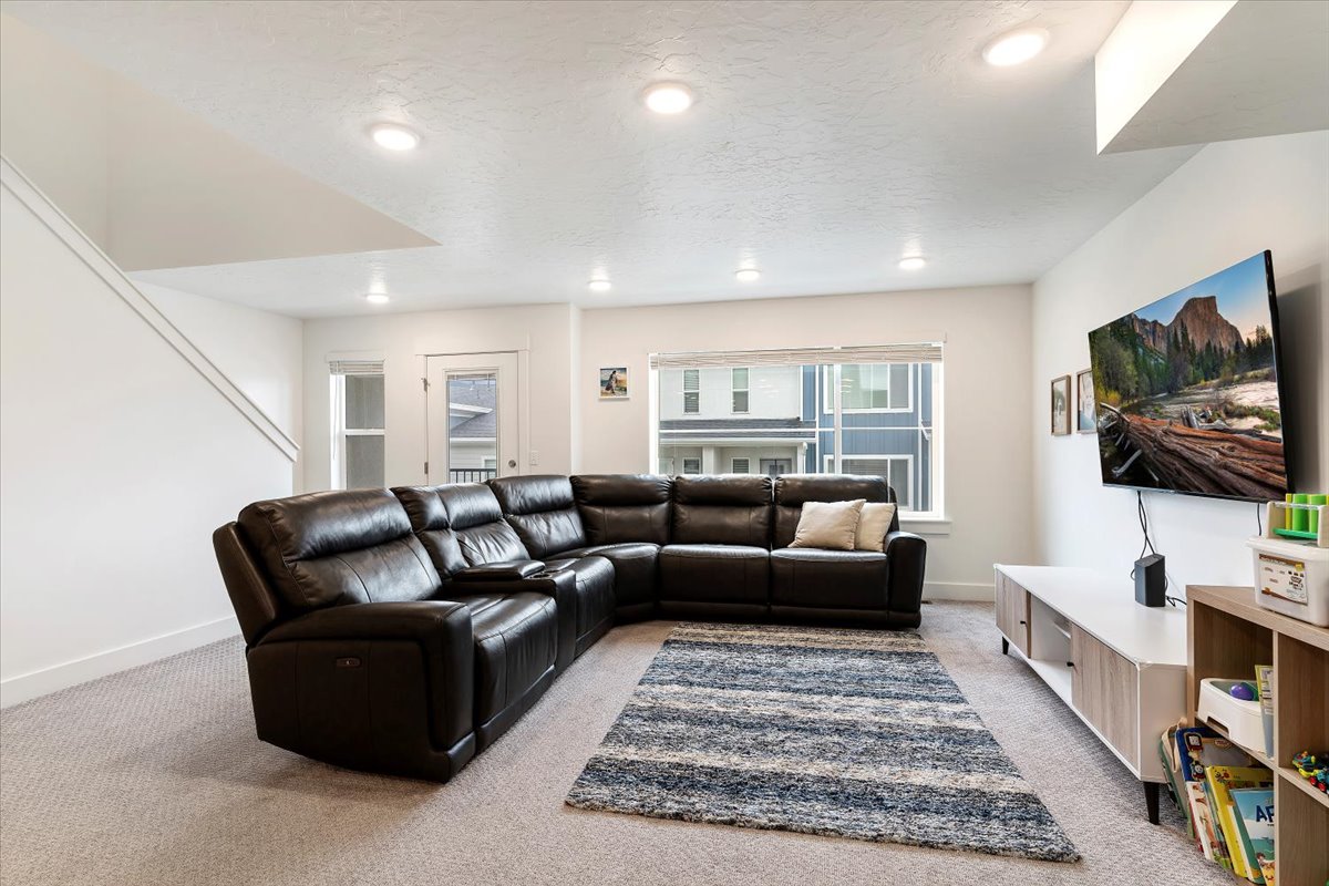 Carpeted living area featuring recessed lighting and a multi-pane window