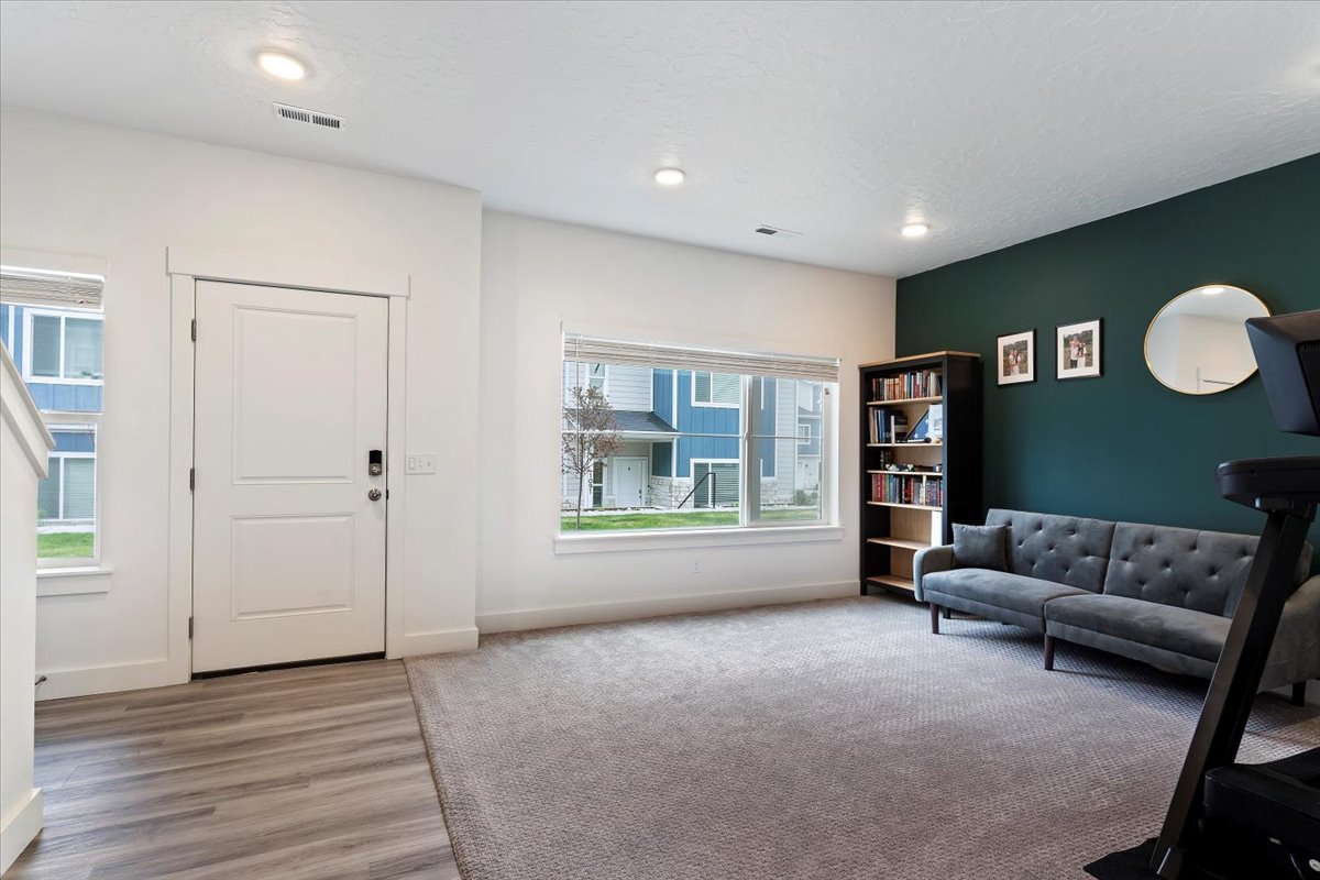 Open concept living area featuring recessed lighting and a contrasting accent wall