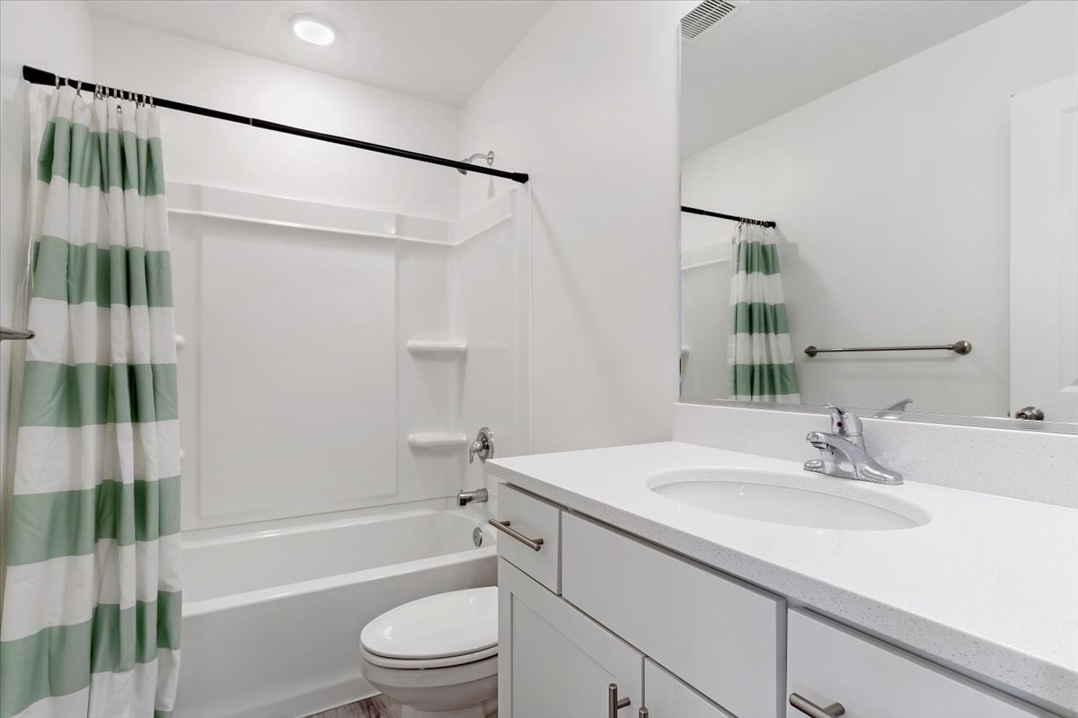 Bathroom featuring a white vanity with an integrated sink, polished chrome faucet, and a large wall-mounted mirror