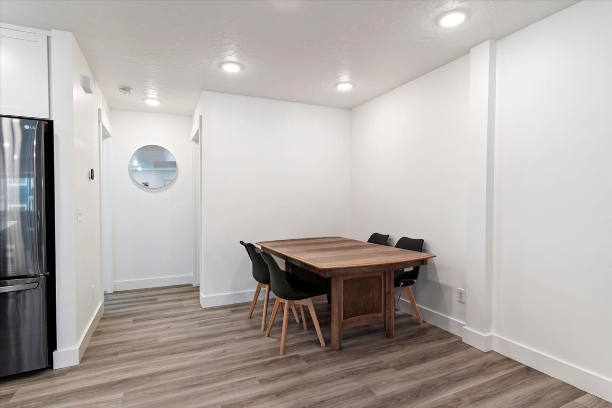 Dining area featuring wood-finish flooring, recessed lighting, and crisp white walls