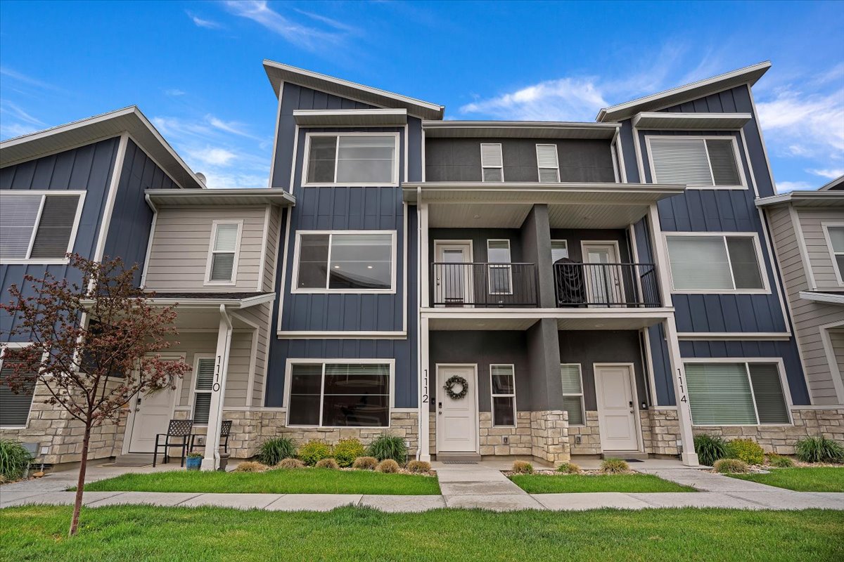 Modern townhome exterior featuring multi-level architecture with stone and siding accents
