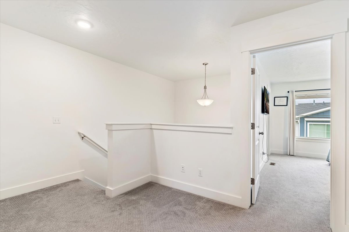 Upper-level landing featuring carpeted flooring and white trimwork