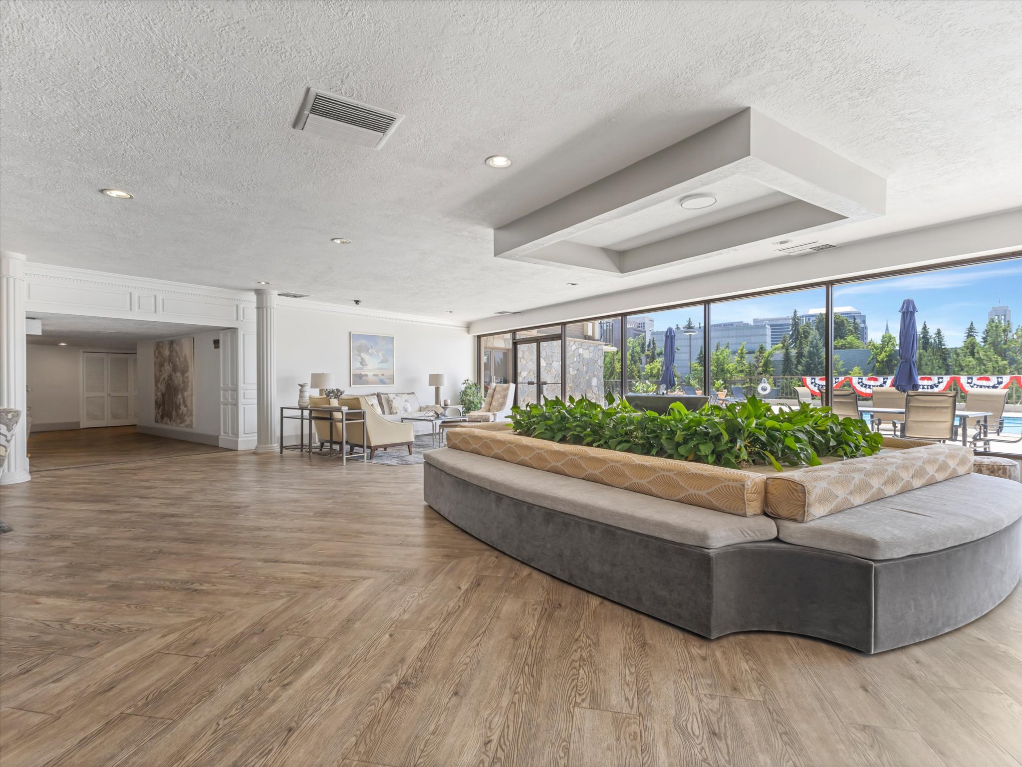 Spacious interior with herringbone wood-finish flooring, recessed lighting, and a decorative ceiling inlay