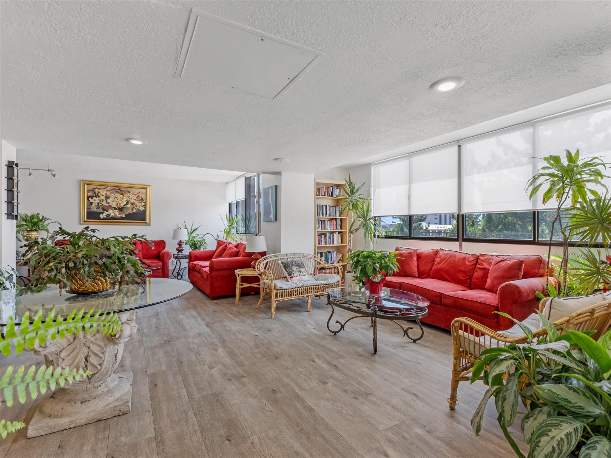 The Garden Room - Spacious interior featuring wood-finish flooring, recessed lighting, and expansive windows with roller shades