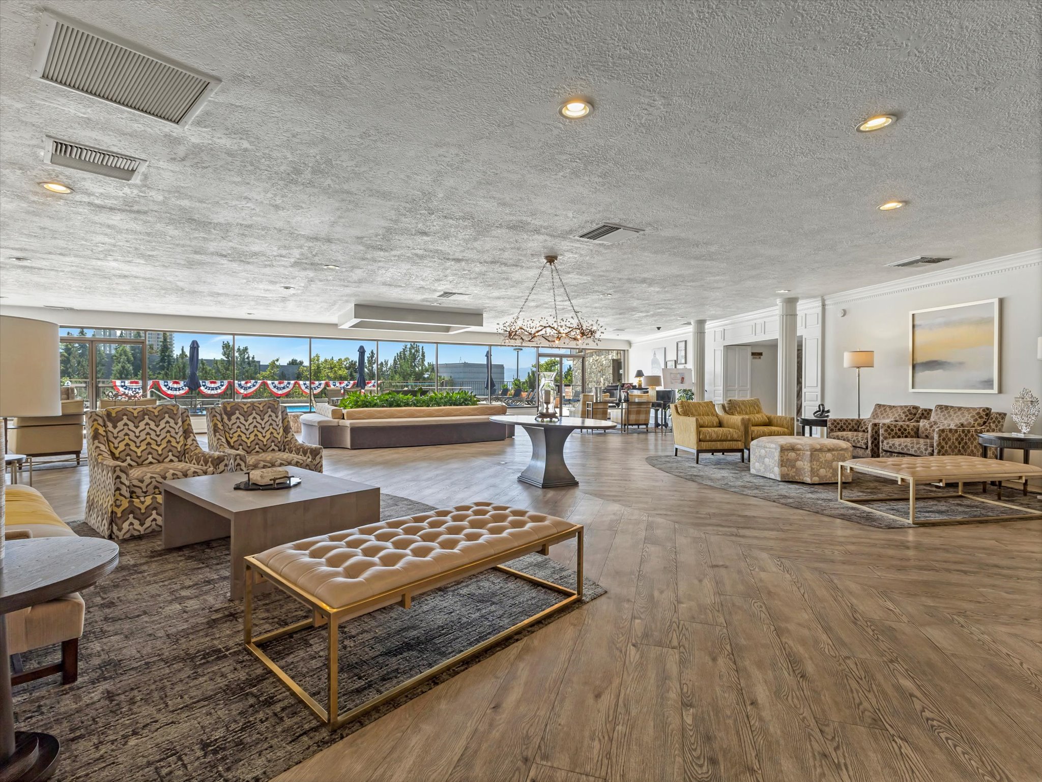 Spacious common area featuring extensive wood-finish flooring, a contemporary chandelier, and recessed lighting
