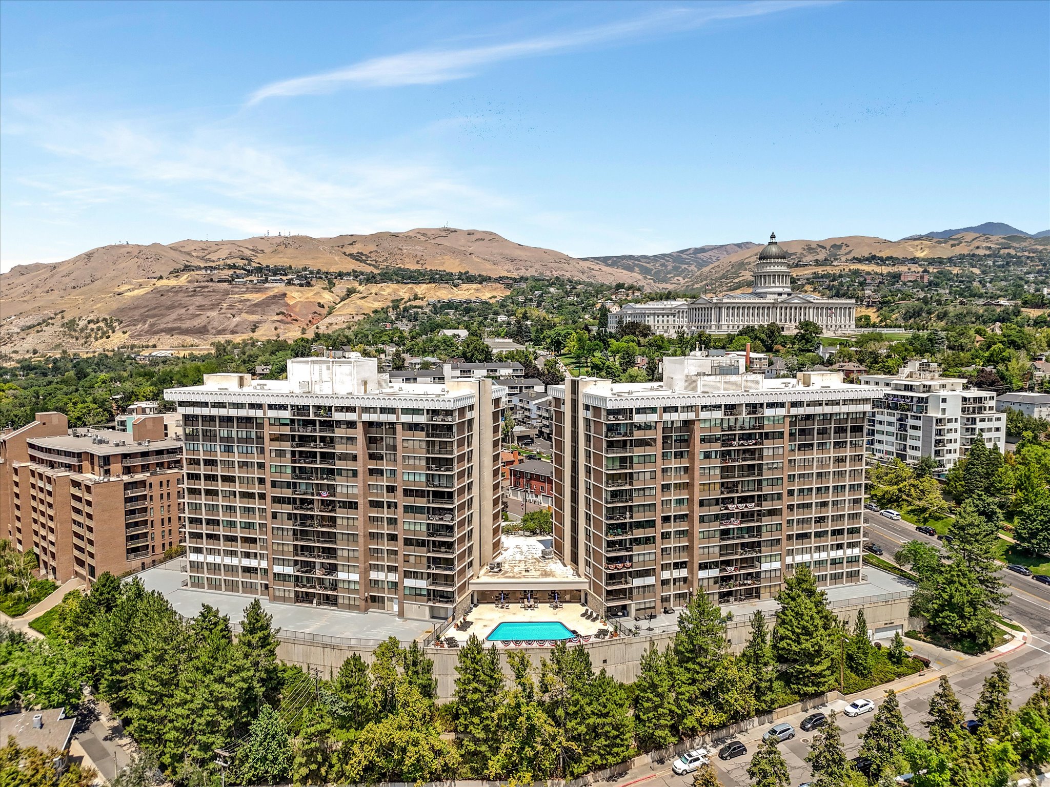 Twin high-rise residential buildings featuring private balconies and an outdoor swimming pool