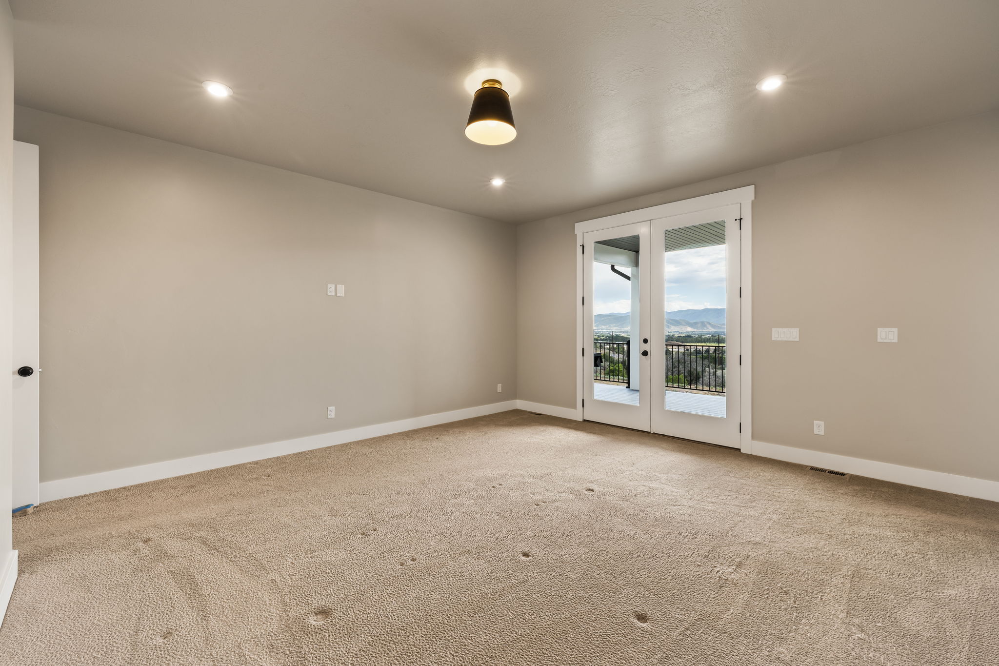 Expansive room featuring light neutral walls, recessed lighting, and a contemporary ceiling fixture
