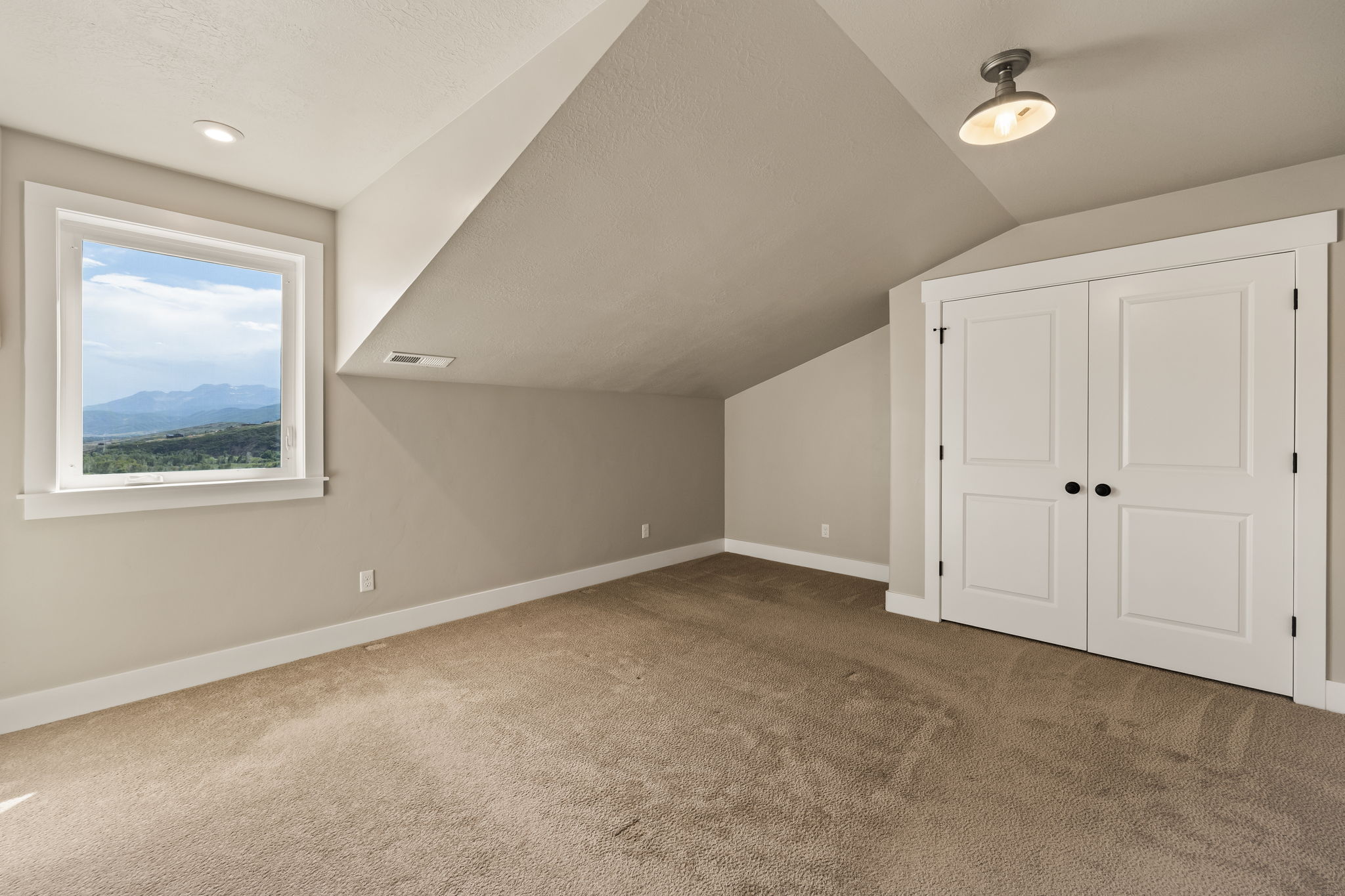 Carpeted room featuring a window with a mountain backdrop, a double-door closet with black hardware, recessed lighting, and a semi-flush mount ceiling fixture