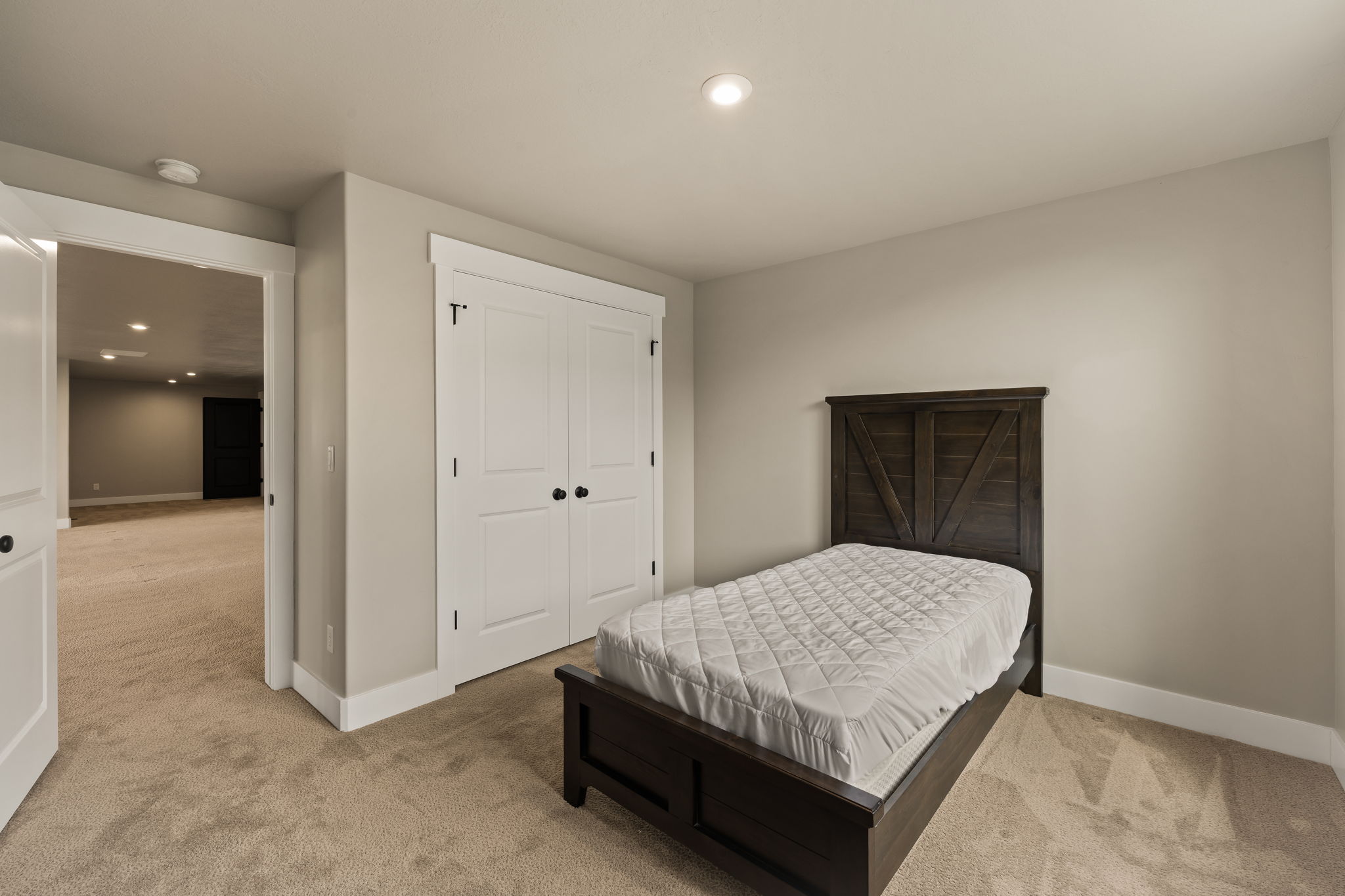 Carpeted room featuring recessed lighting, a two-panel closet with matte black hardware, and a framed doorway