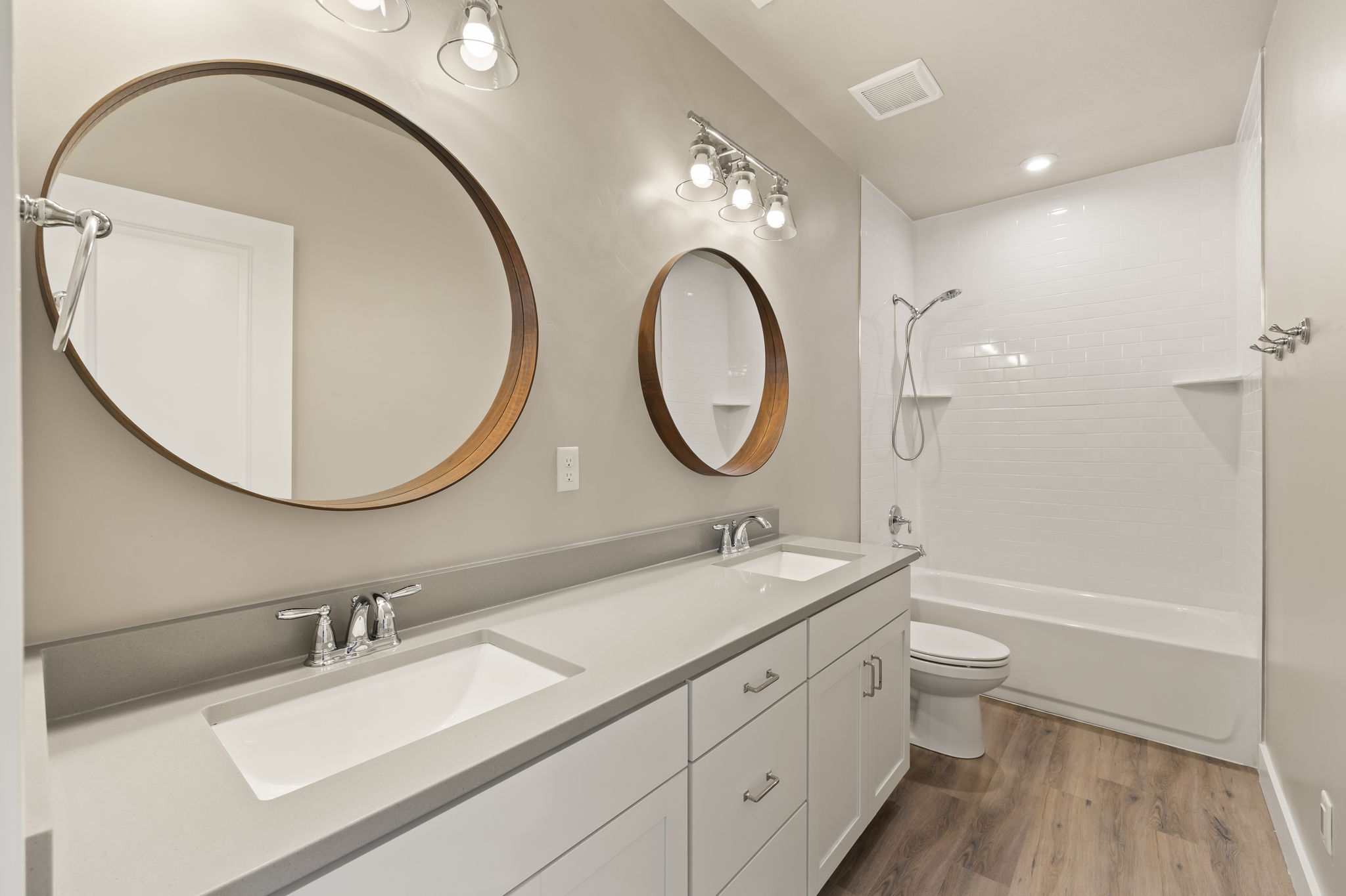Bathroom featuring a double vanity with stone countertops, individual sinks, and chrome fixtures