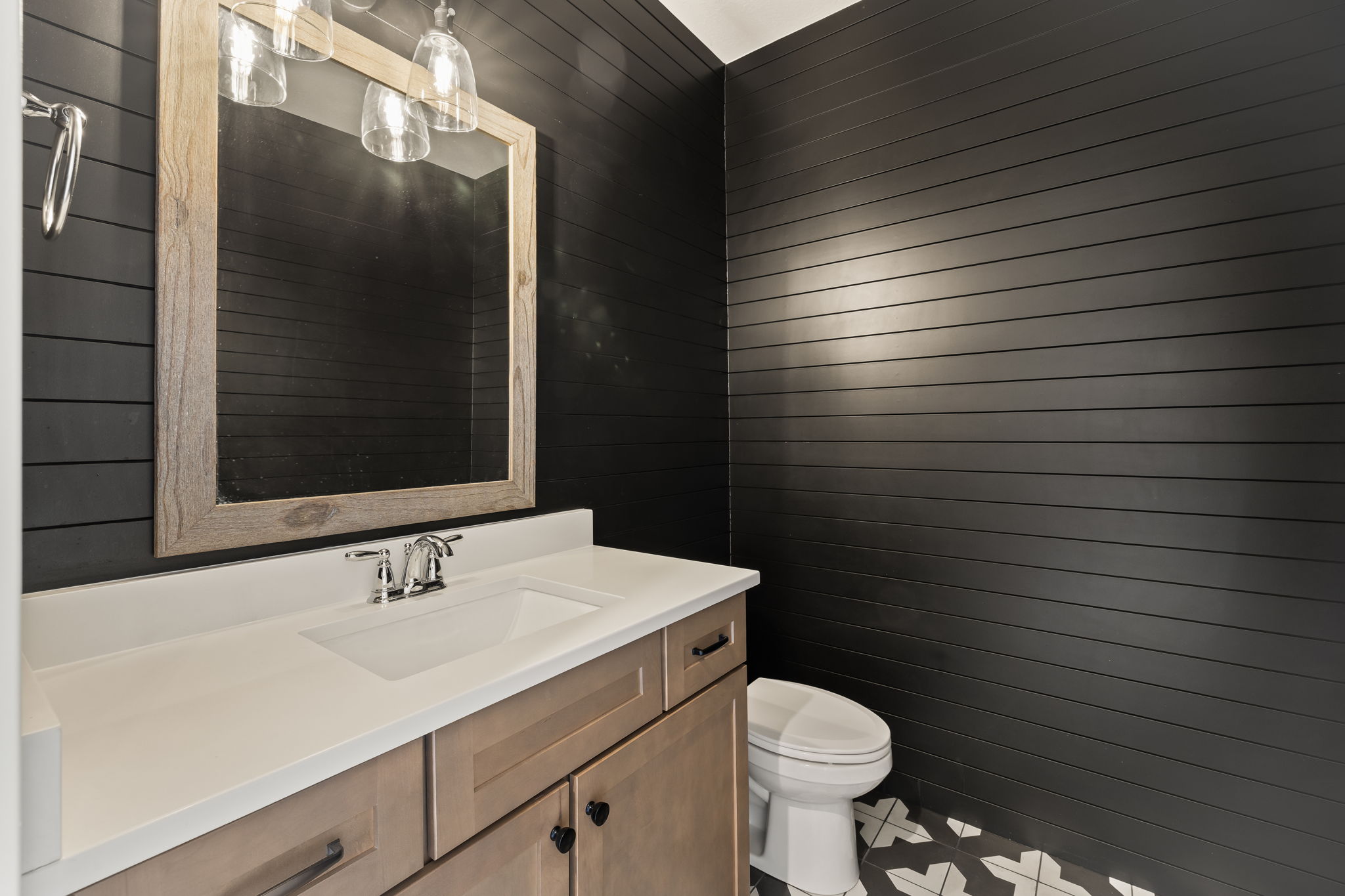 Vanity with an integrated rectangular sink, chrome faucet, and light wood-tone cabinetry