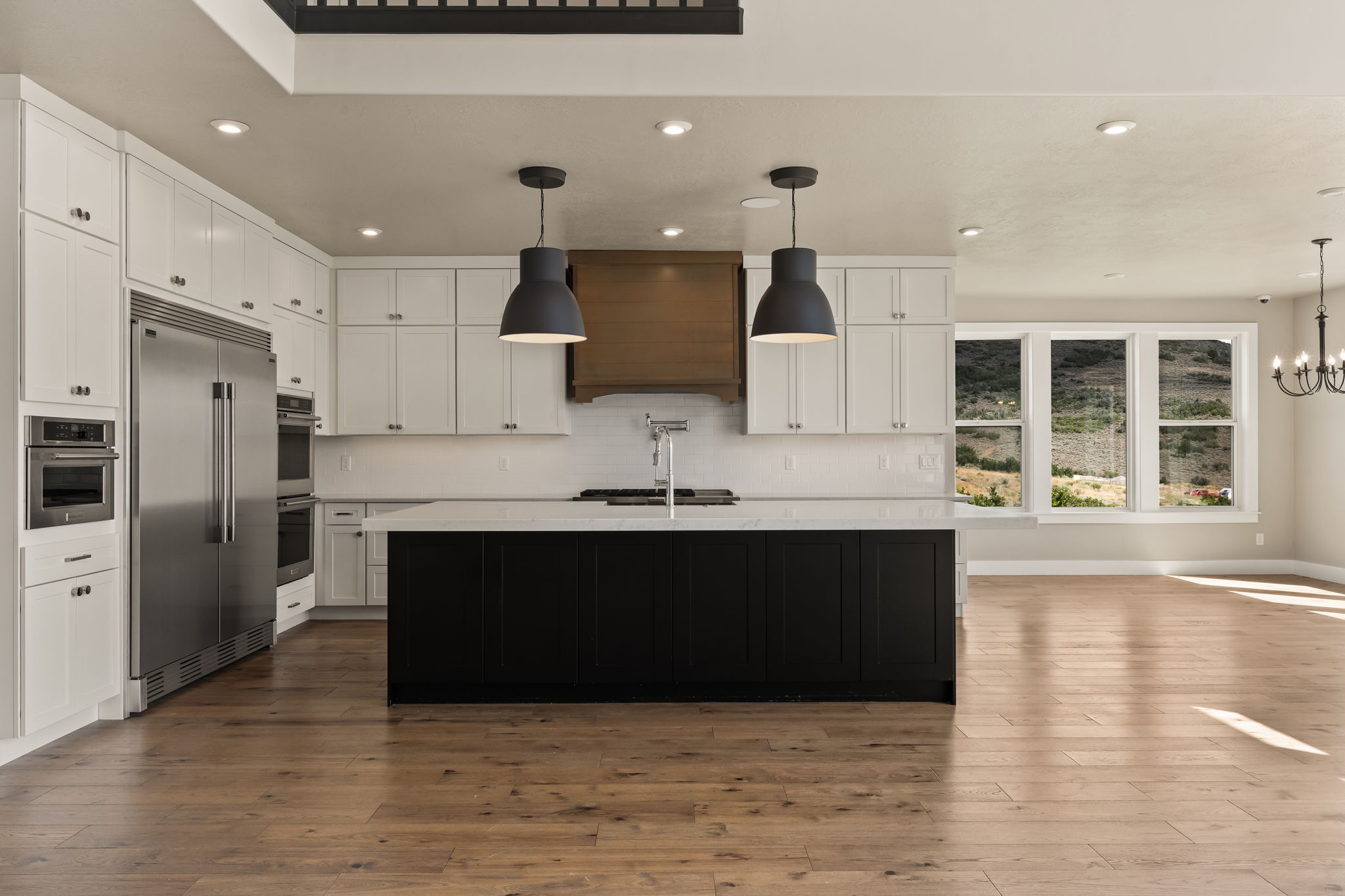 Contemporary kitchen featuring white cabinetry, a dark island with a light-colored countertop, and integrated stainless steel appliances