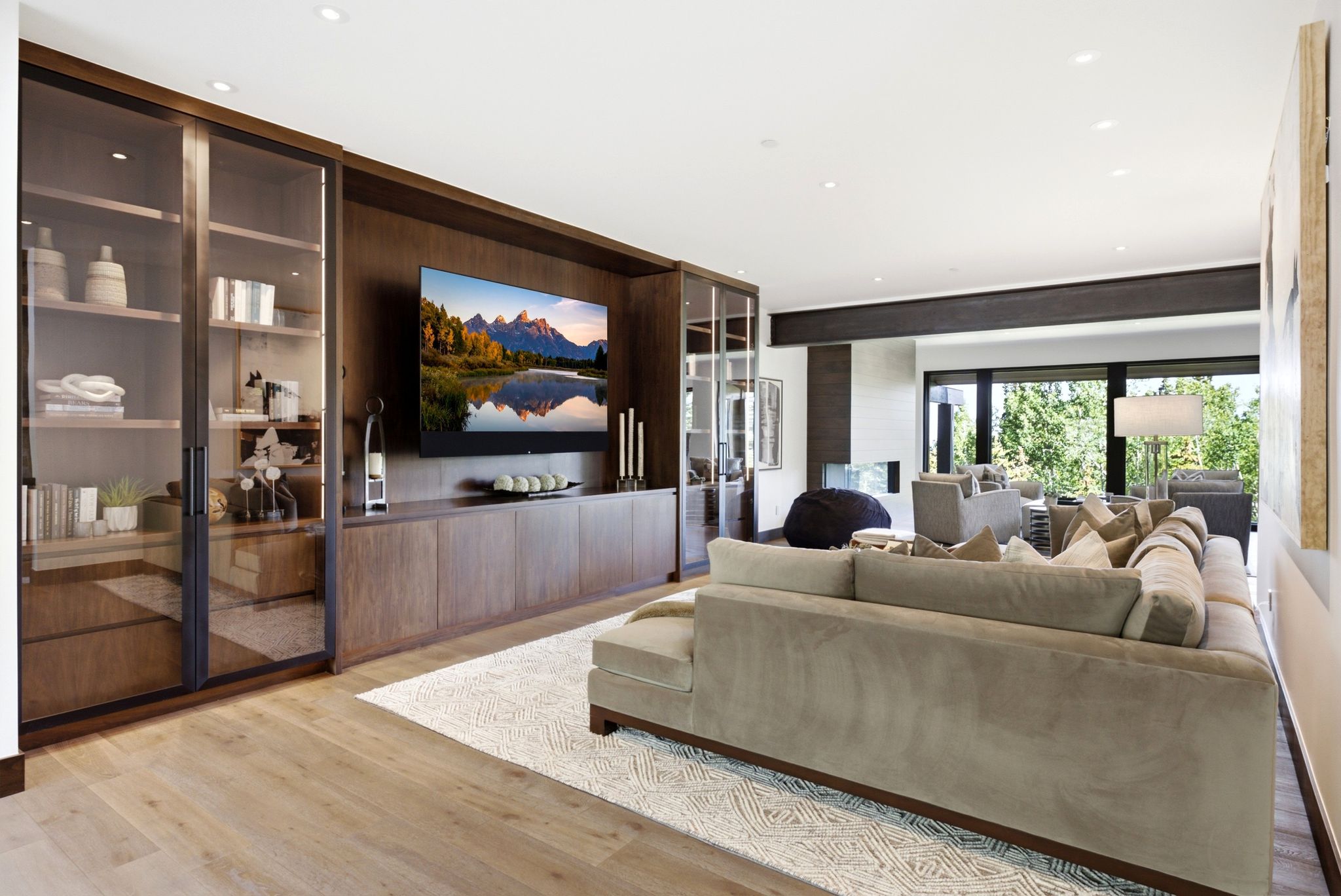 Integrated wood-finish media center with built-in cabinetry and glass-front display cases