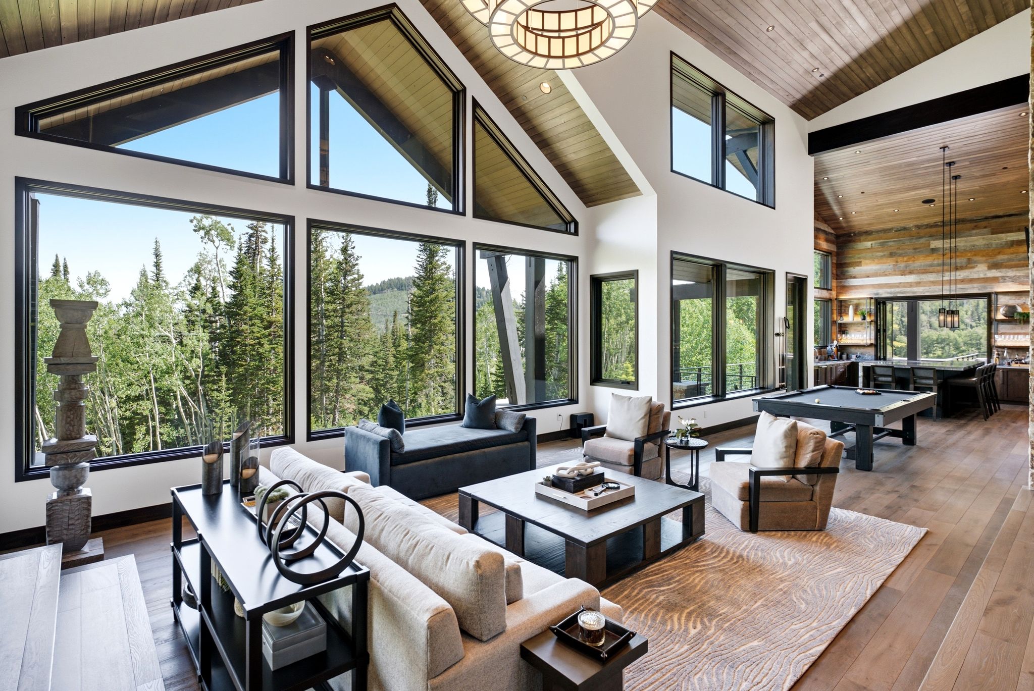 Great room featuring expansive windows, wood-finish flooring, a vaulted ceiling with exposed wood, a built-in bar, and a billiards table
