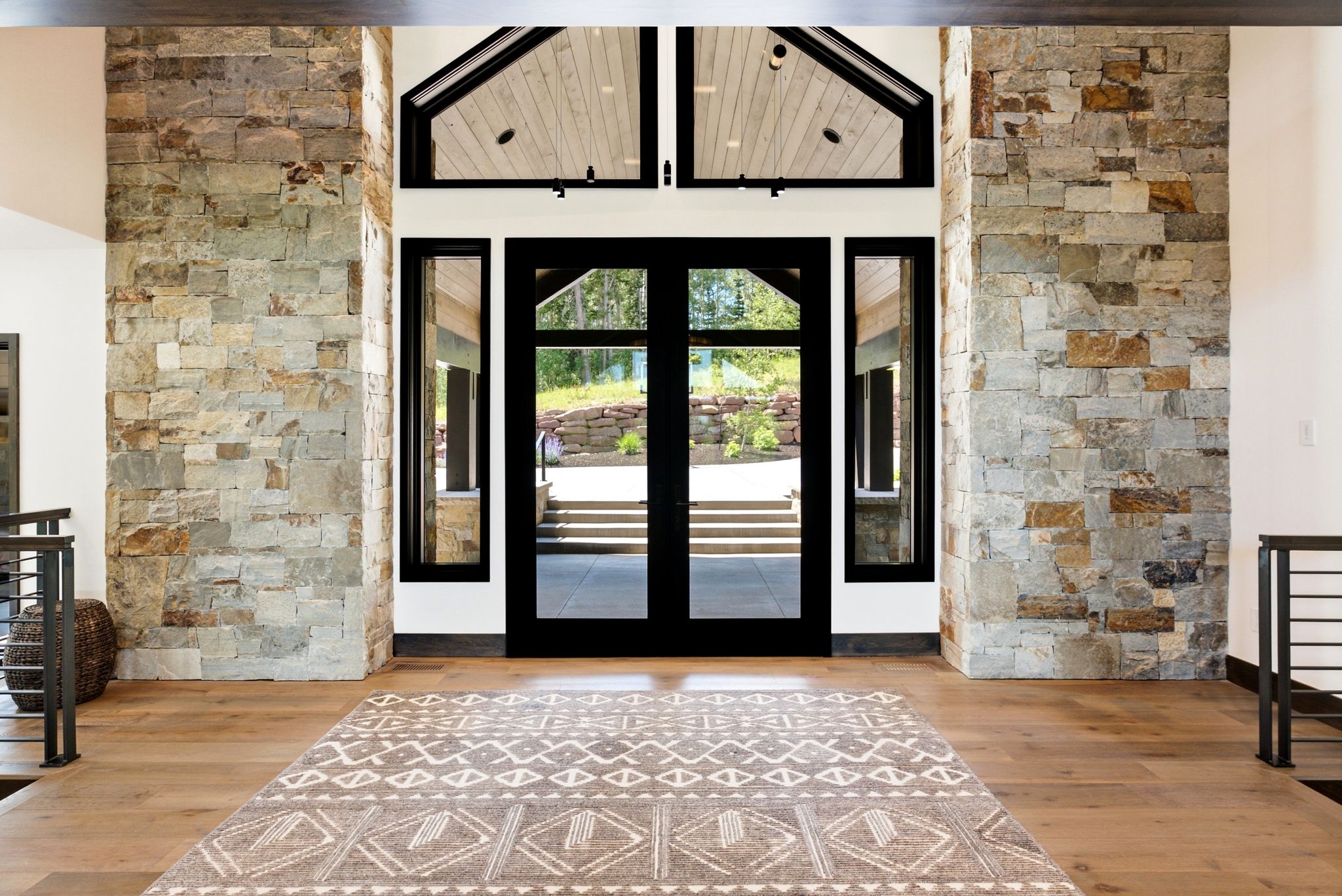 Grand entry featuring a double-door entrance with sidelights, transom windows, and a vaulted ceiling with wood paneling