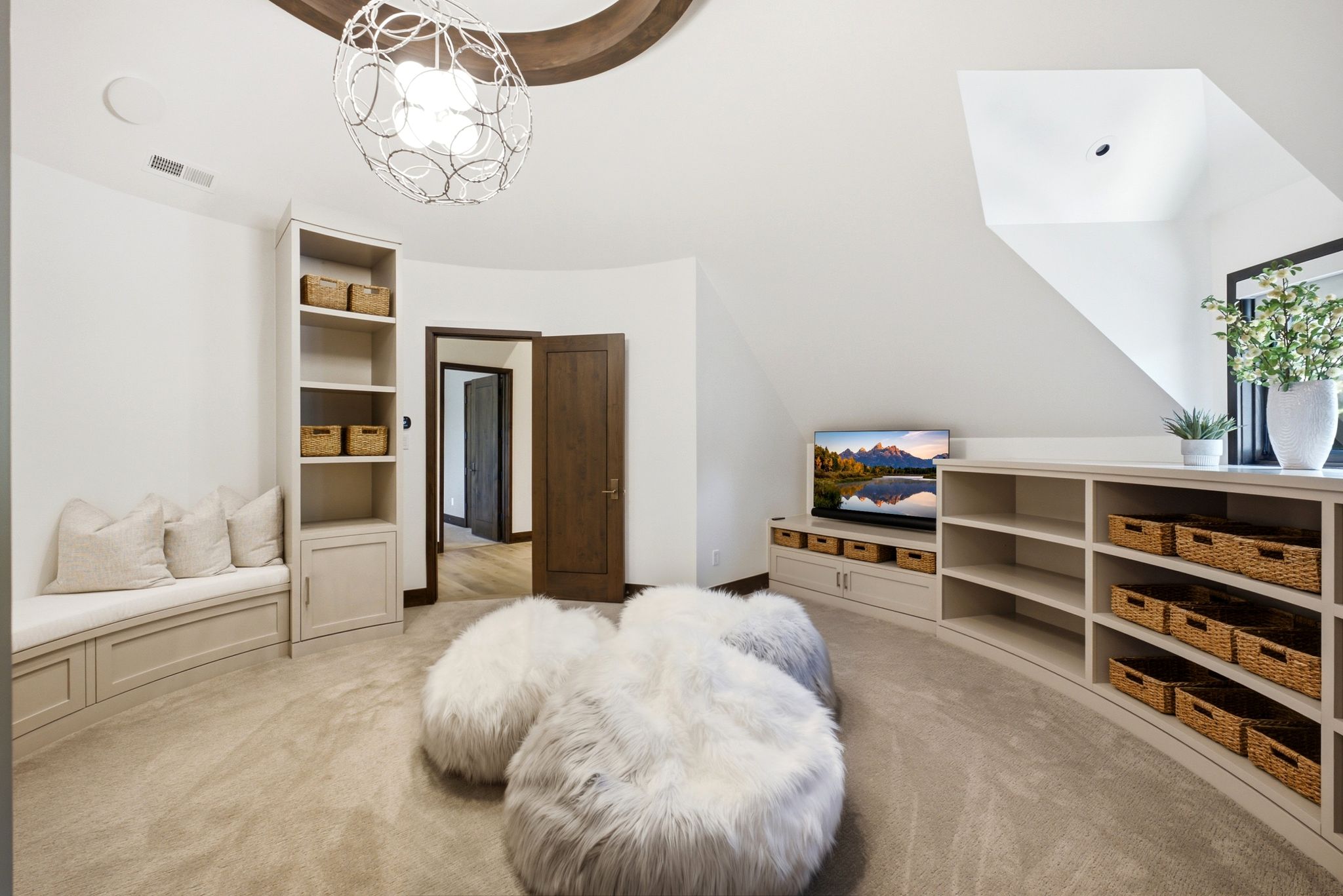 Curved wall features a long built-in shelving unit with open storage and integrated cabinetry