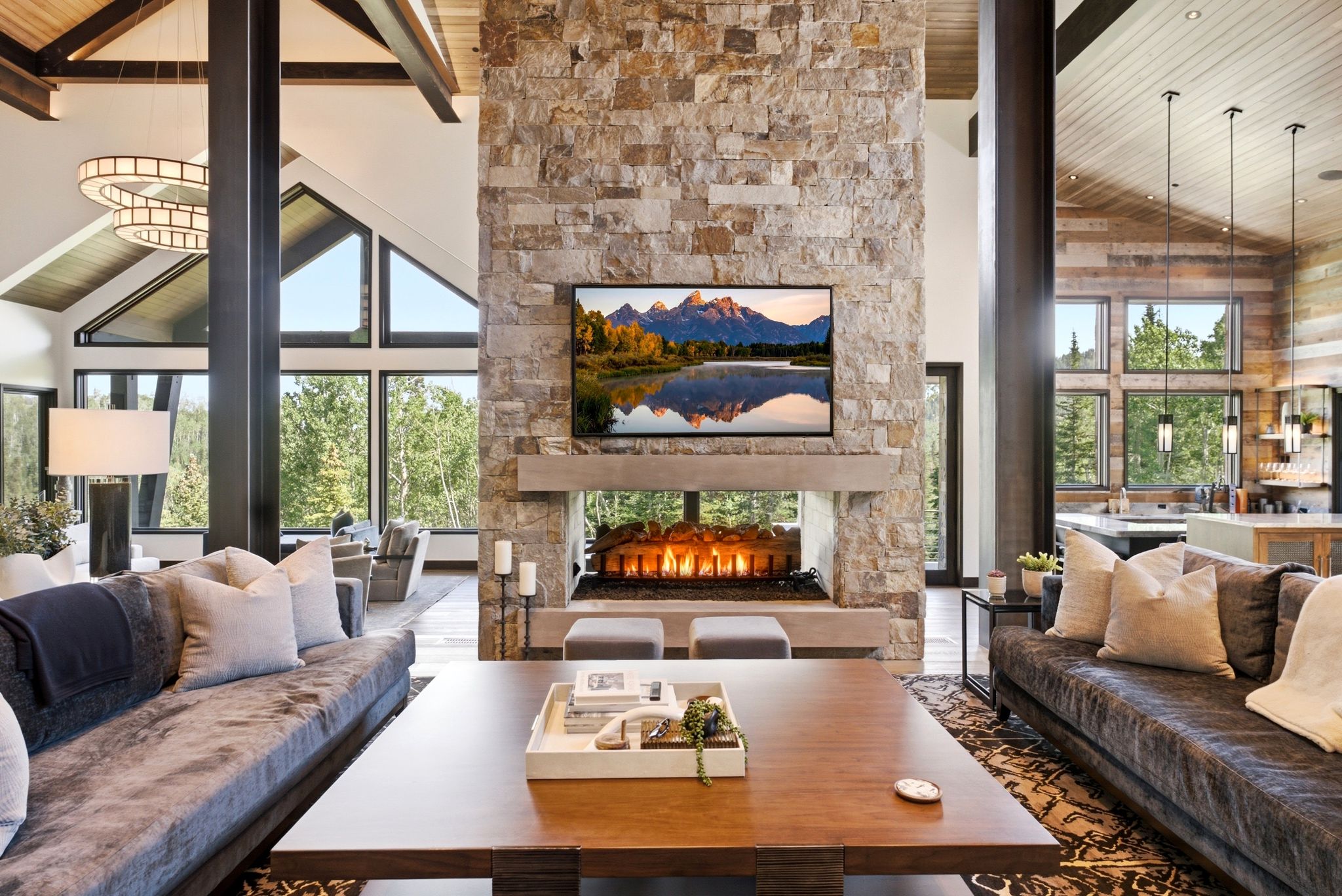 Vaulted living area featuring a stone fireplace with a floating hearth, a wood-finish ceiling, exposed structural beams, and large windows