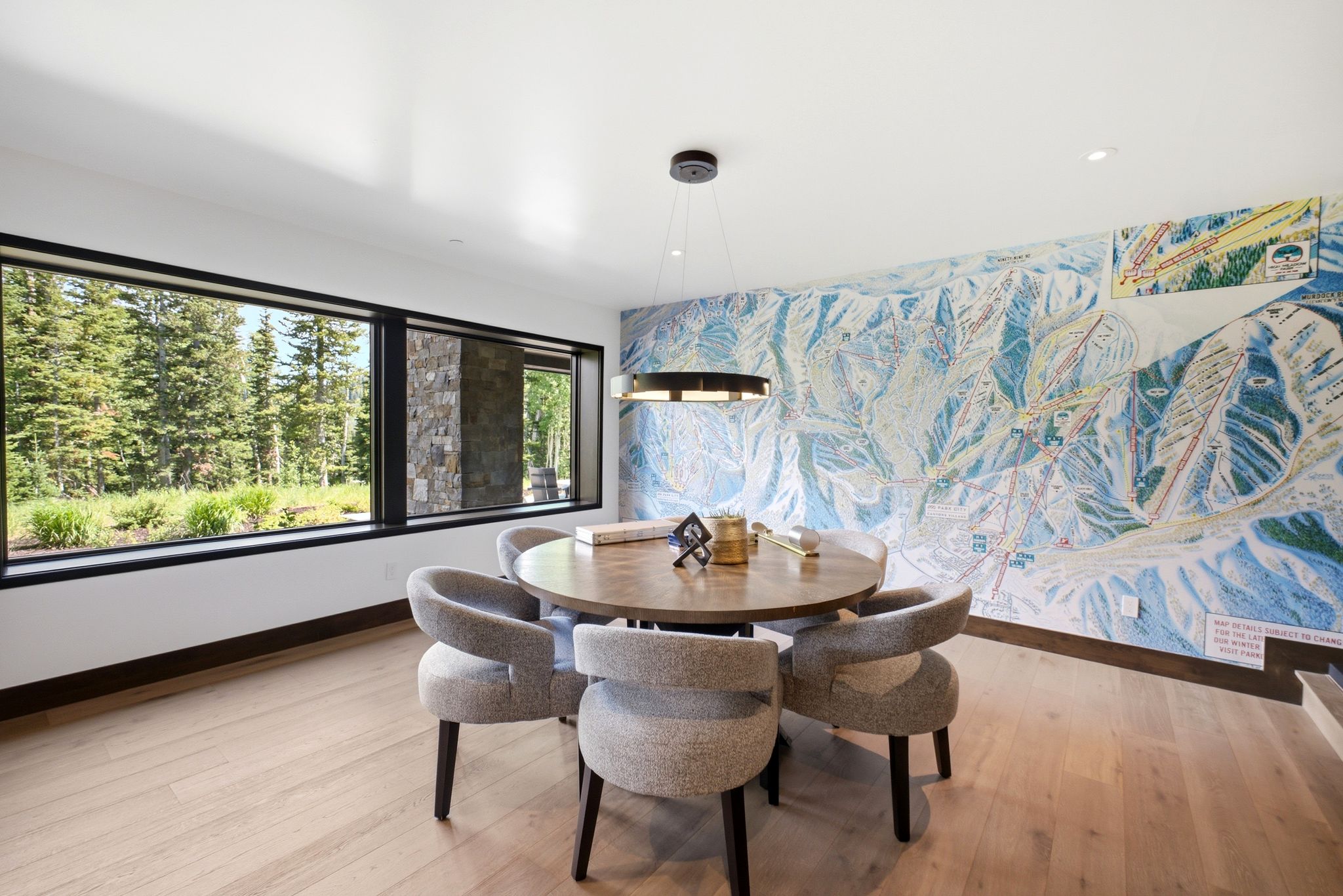 Spacious room featuring panoramic windows, wood-finish flooring, and a stone accent column