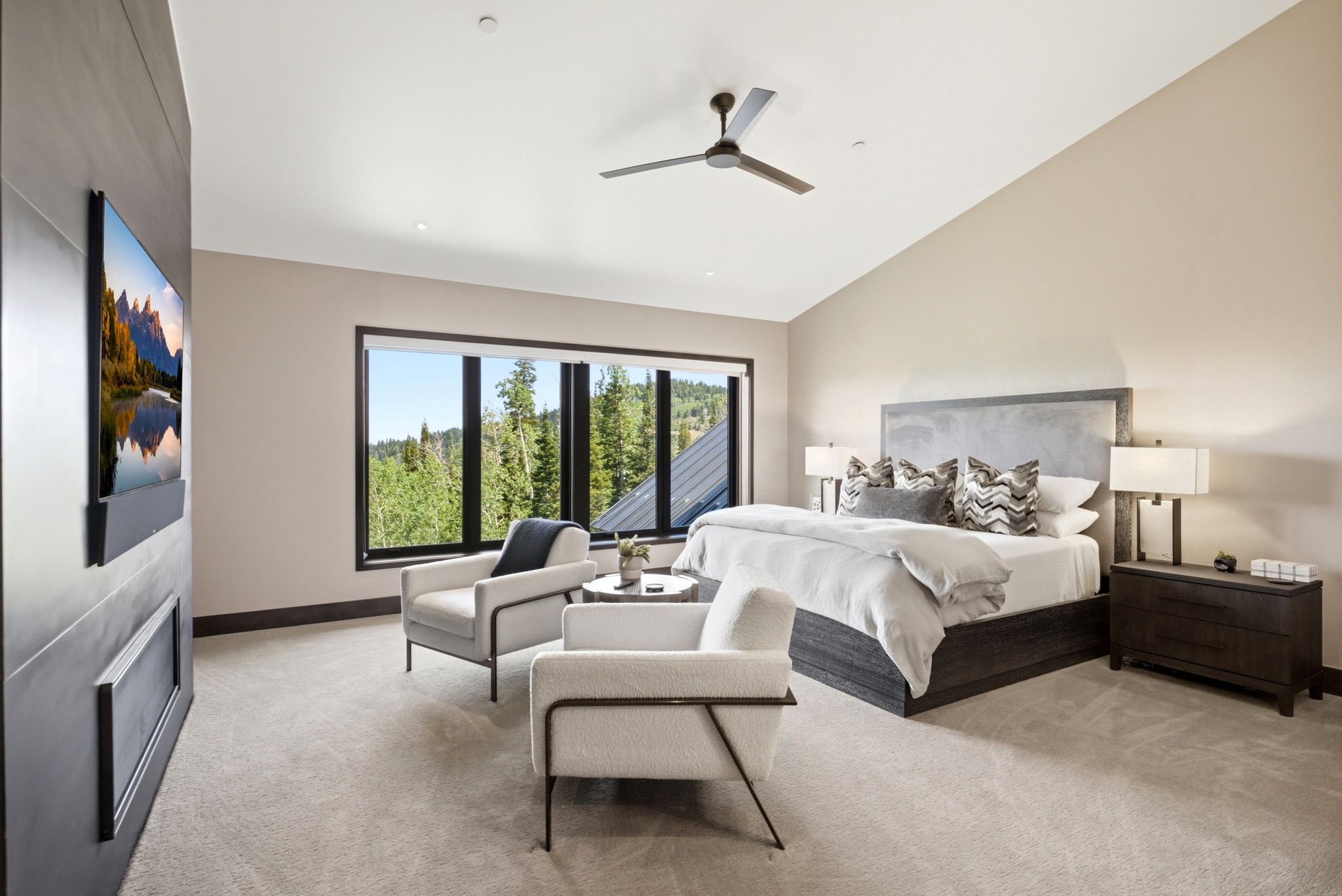 Spacious bedroom featuring vaulted ceilings, a contemporary ceiling fan, and large windows