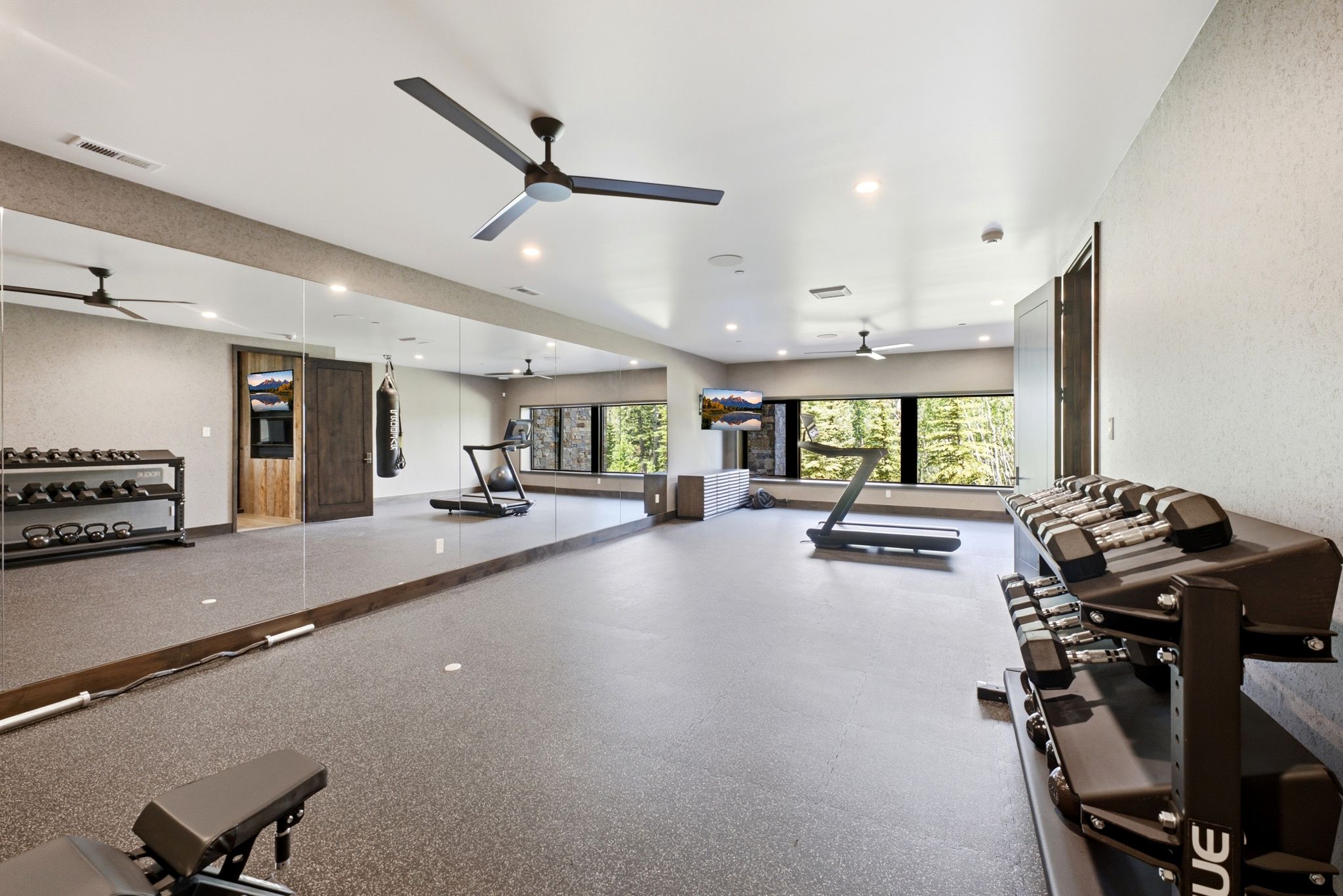 Spacious room featuring full-wall mirrors, recessed lighting, and multiple ceiling fans
