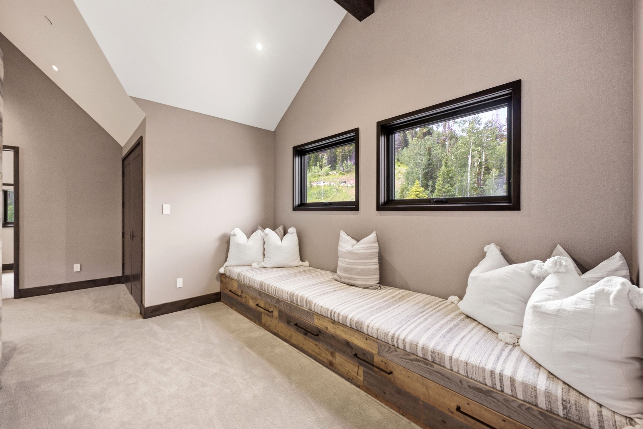 Built-in window bench with integrated storage drawers, complemented by two horizontal windows with dark trim