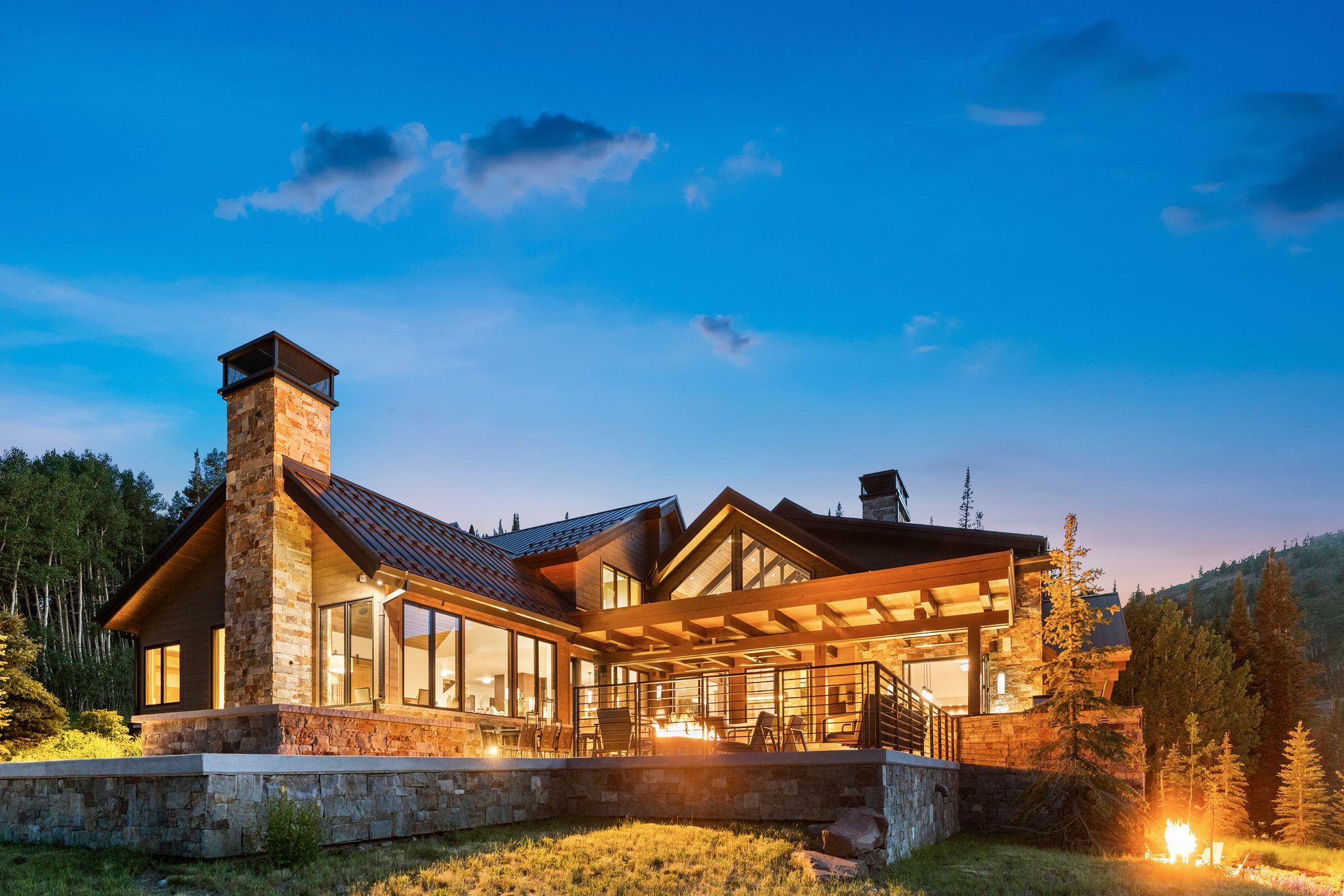 Stone and wood-clad residence featuring a covered outdoor patio