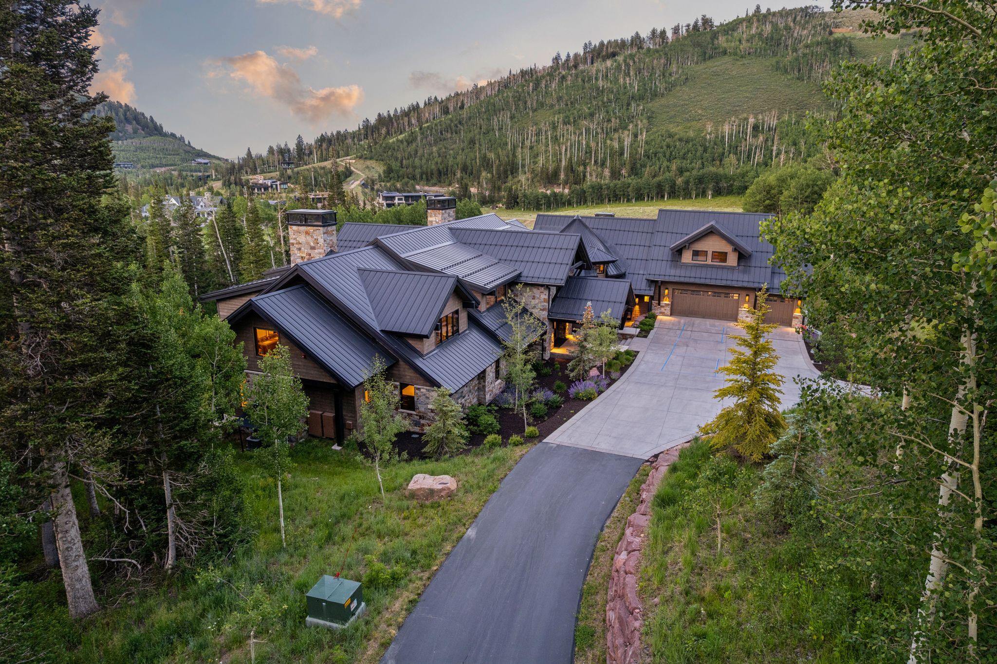 Mountain retreat featuring a stone and wood facade, multiple gables, and a dark metal roof