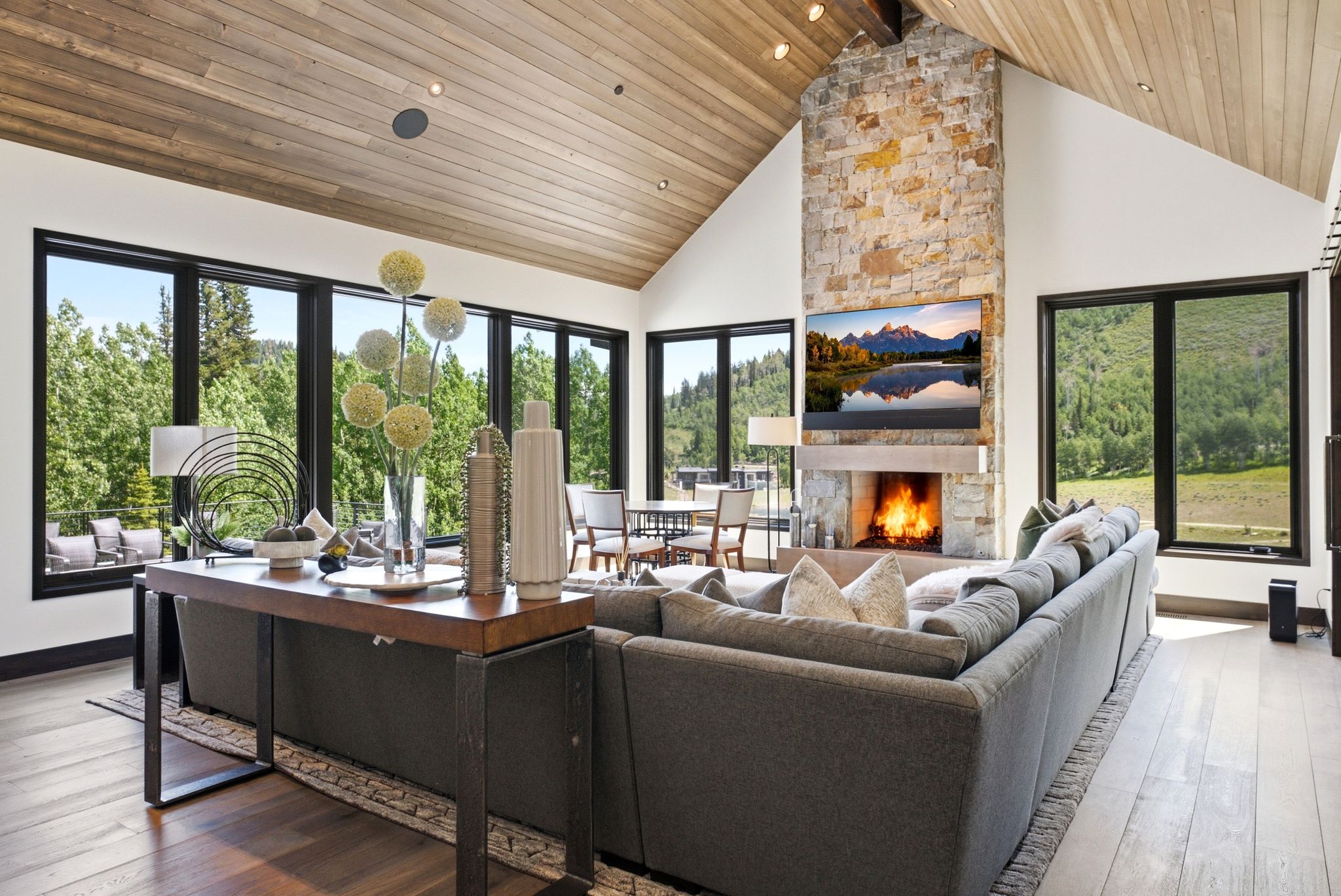 Vaulted wood-finish ceiling complemented by a stone fireplace with hearth