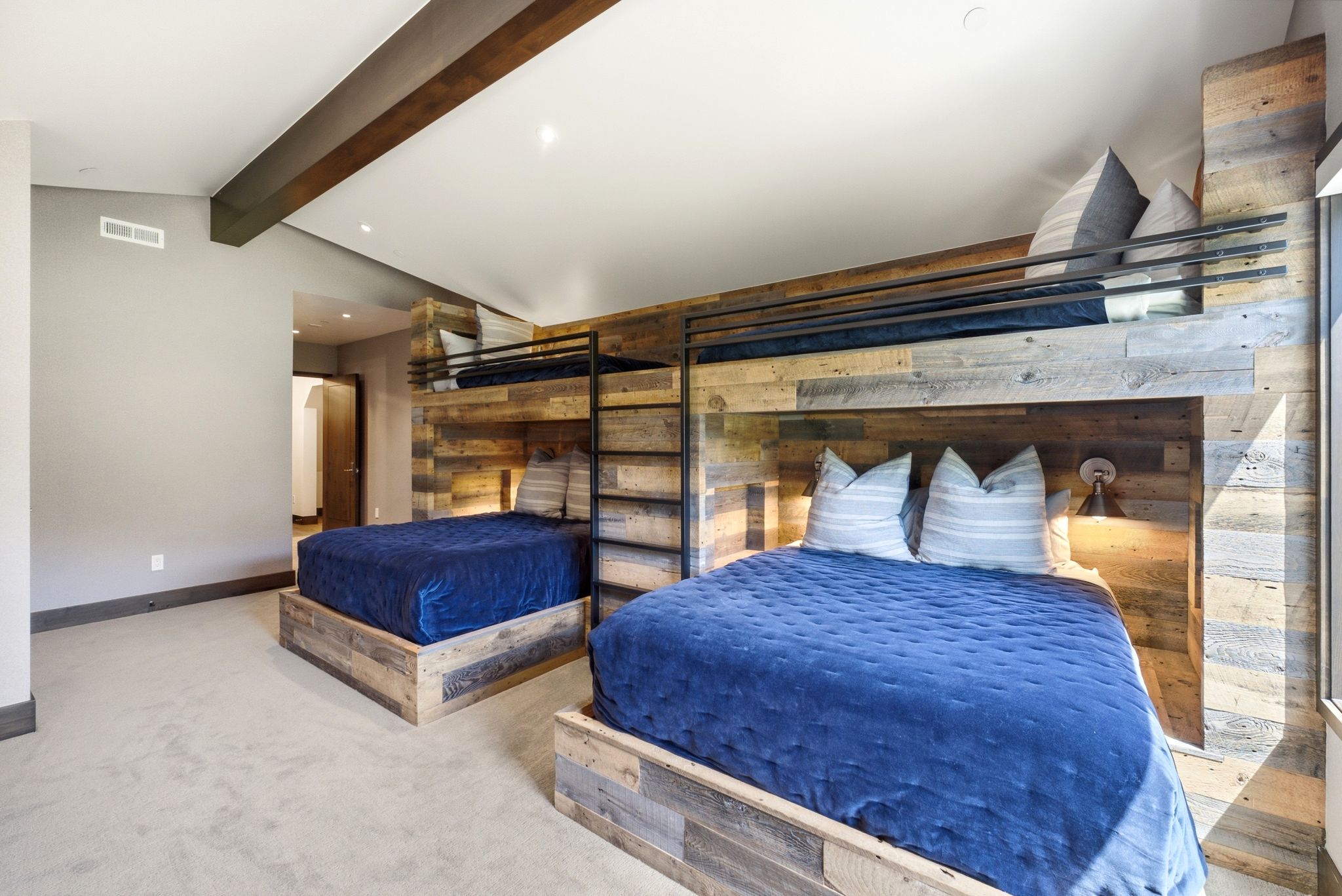 Spacious room featuring two built-in platform beds and a custom wood-paneled bunk bed system