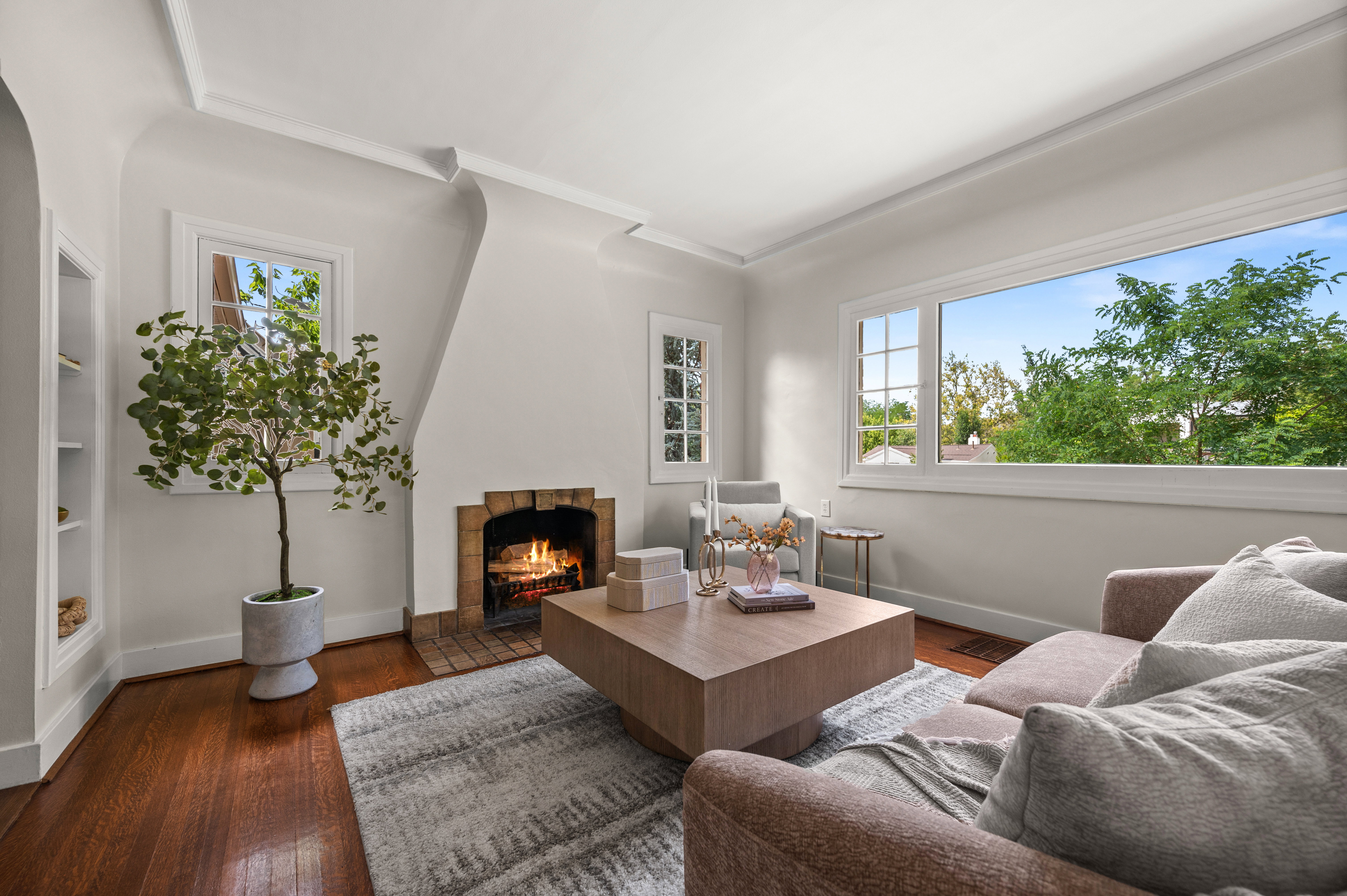 Living area featuring warm wood-finish flooring and a brick fireplace