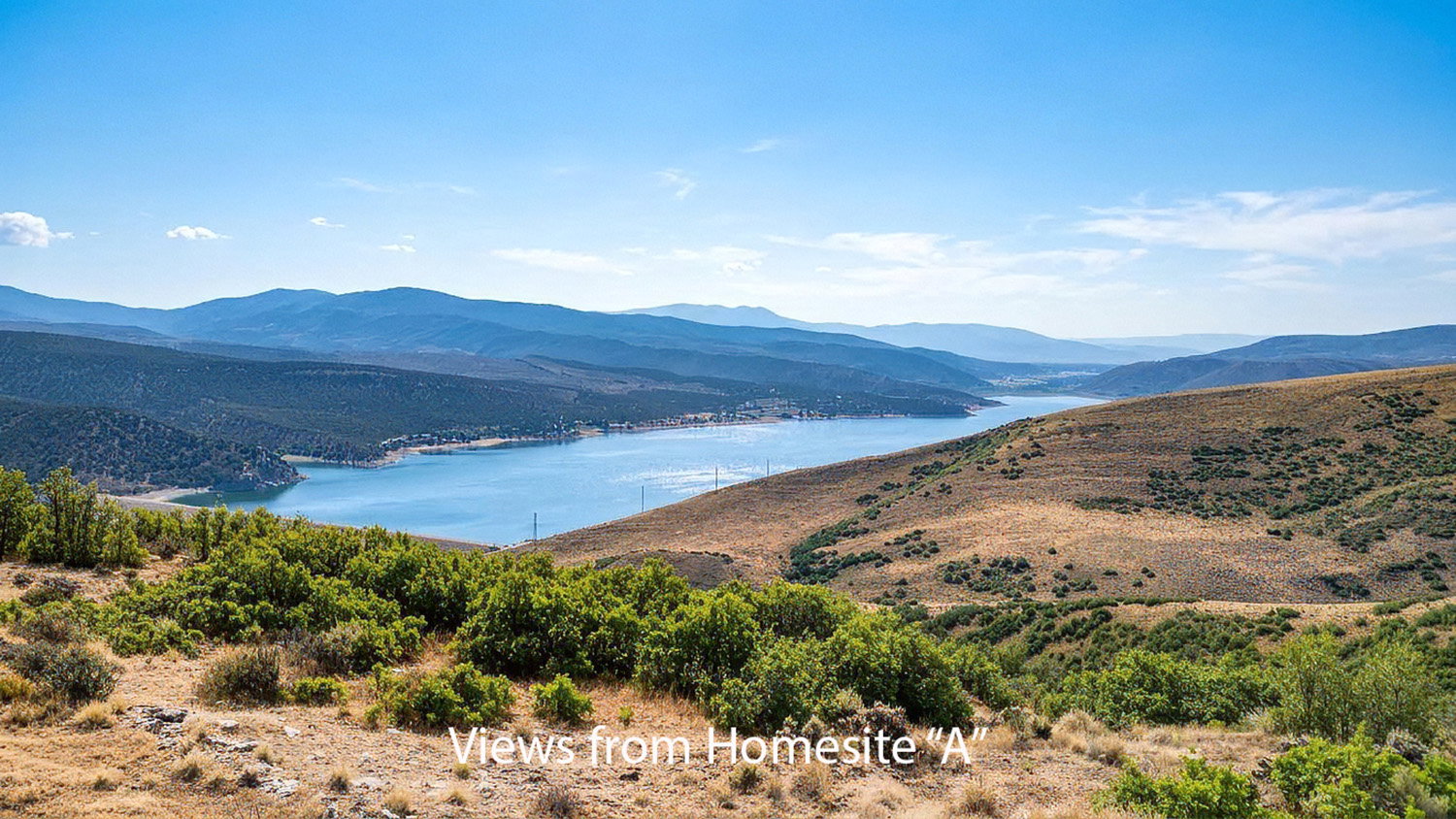 Expansive landscape featuring distant mountains, a large body of water, and natural brush