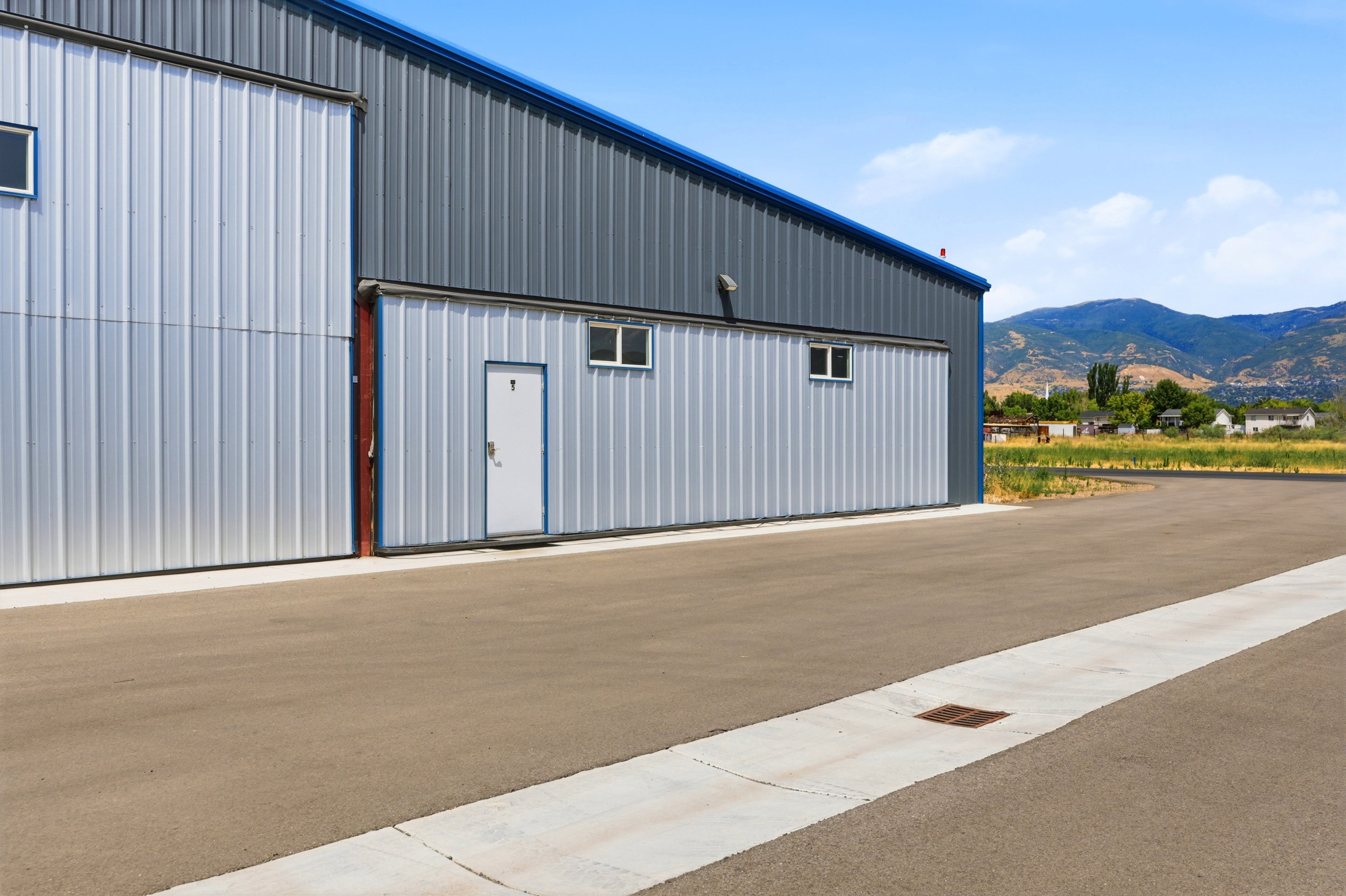 Corrugated metal exterior with a blue roofline and multiple windows