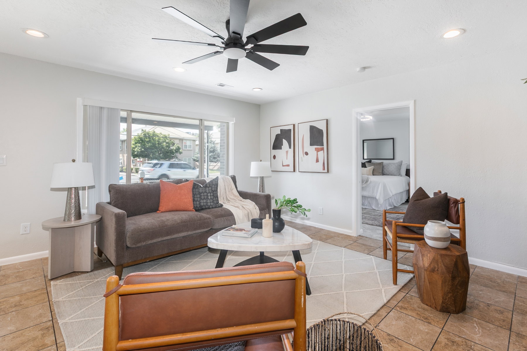 Spacious living area featuring tile flooring, a large window, recessed lighting, and a contemporary ceiling fan