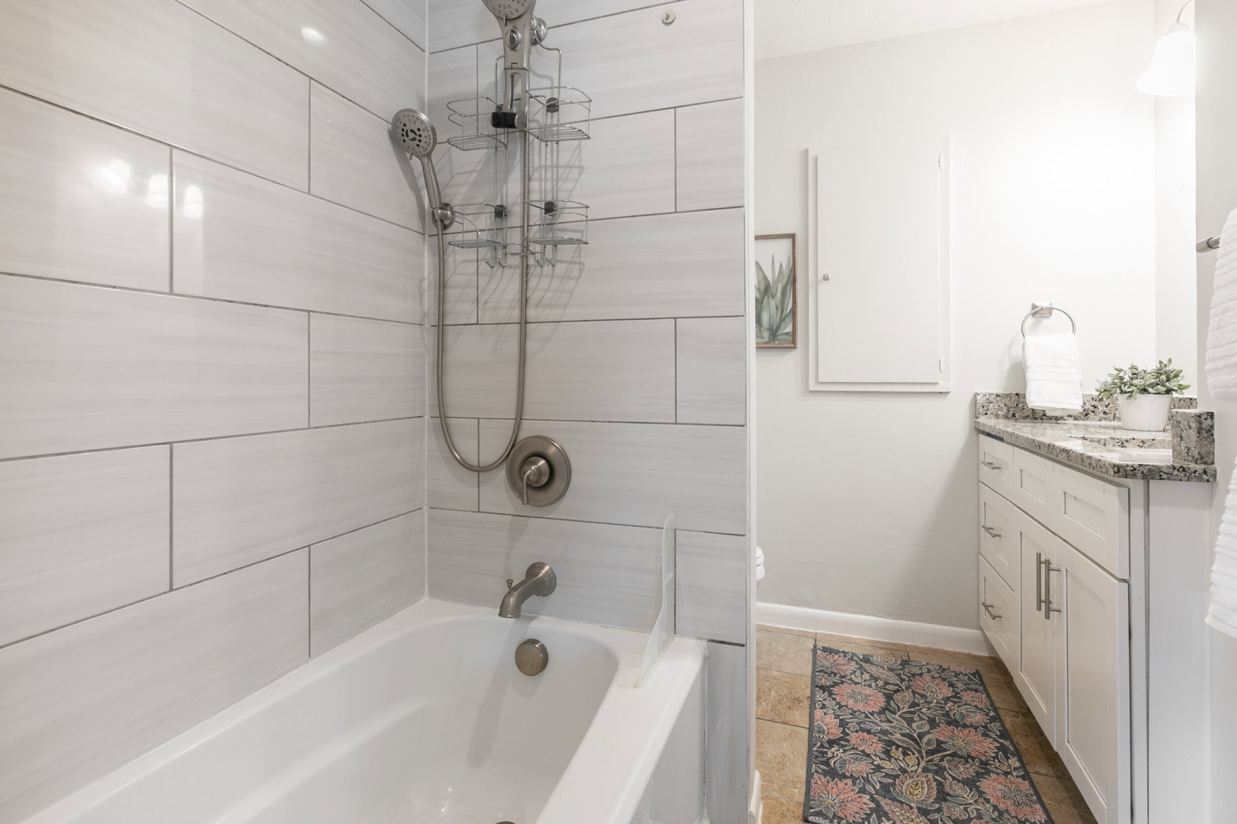 White subway tile bath surround with a multi-function showerhead and brushed nickel fixtures